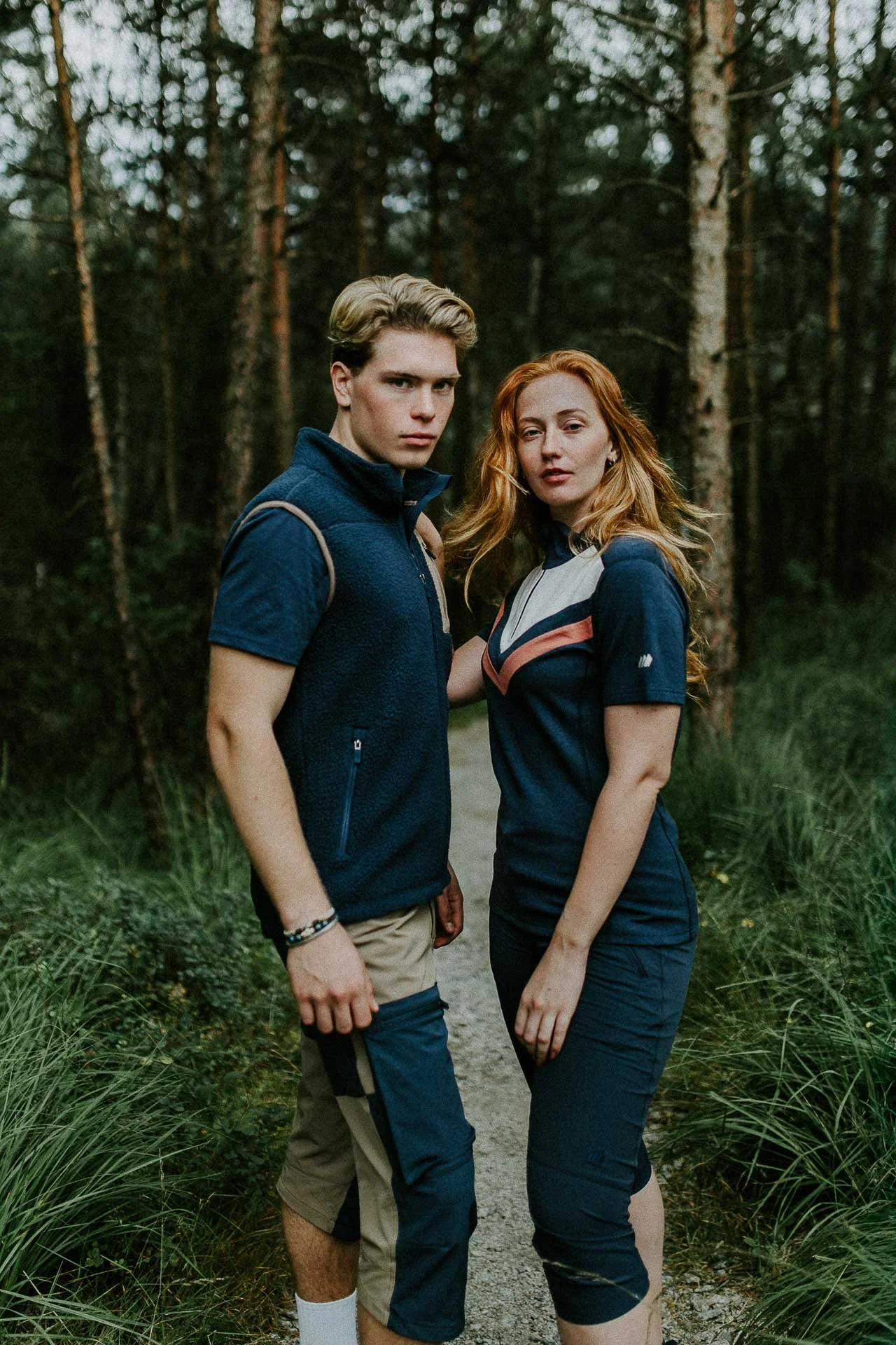 to personer som ser mot kameraet stående med skog i bakgrunnen Reklamefotografering av modeller til kampanje for Skogstad bilder tatt i preikestolenområdet bilder av turklær