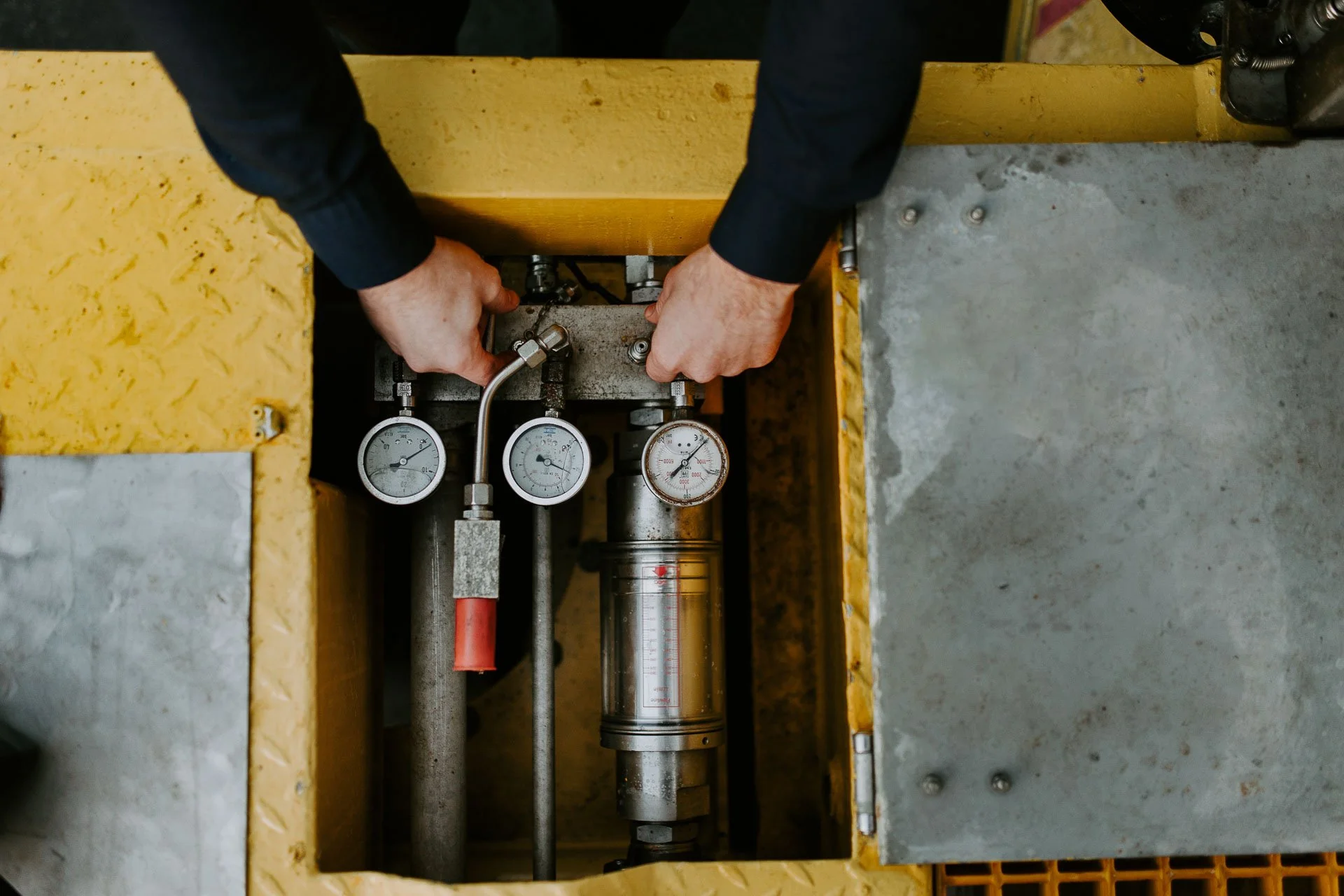 Hender som jobber detaljbilde gule farger reklamefotografering for nofo norsk oljevernberedskap tatt i naturlig lys