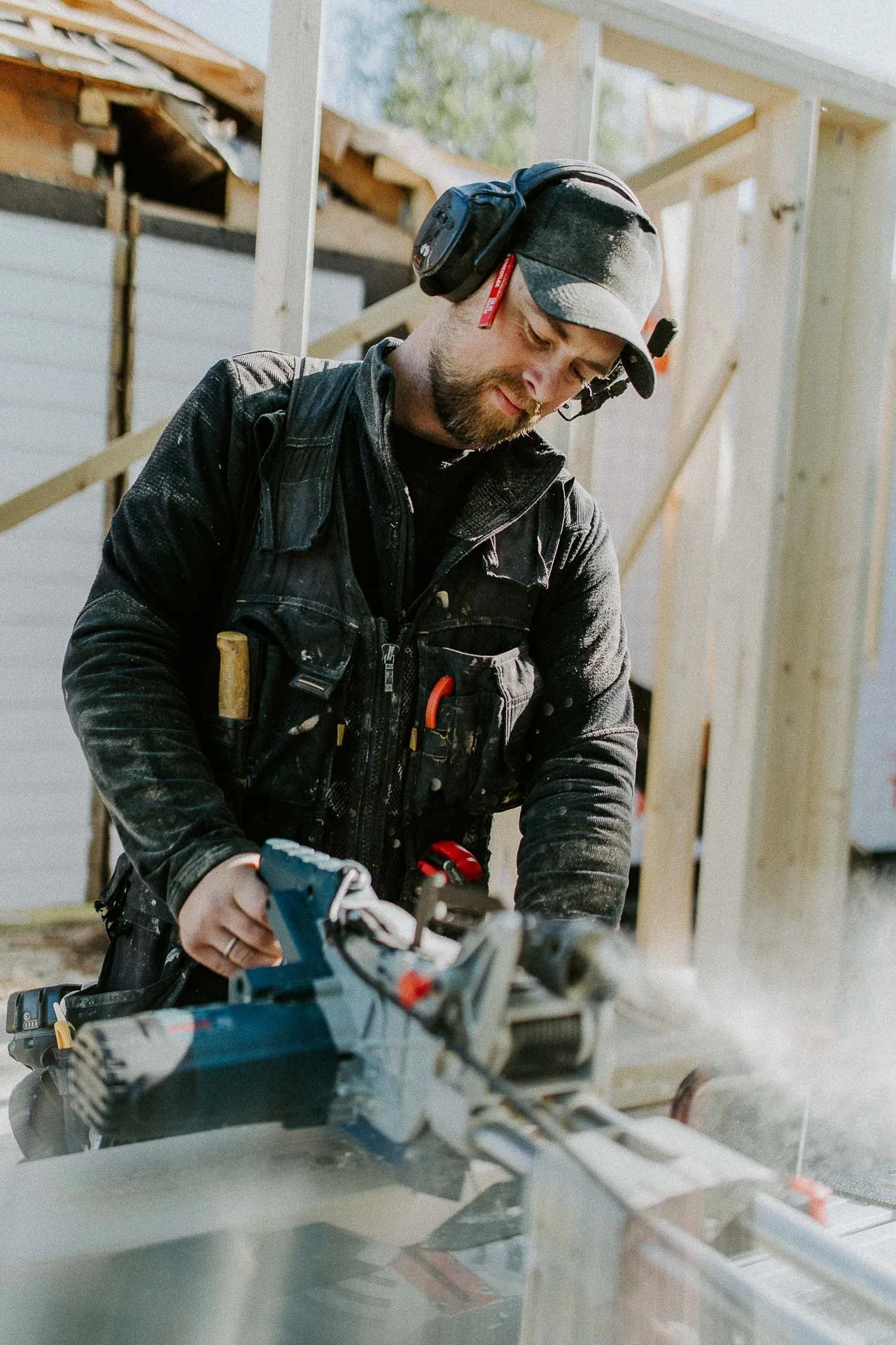 Reklamefotografering til kampanje for Altibox bedrift tatt i naturlig lys bilde av tømrer som er i arbeidssituasjon pusser opp hus