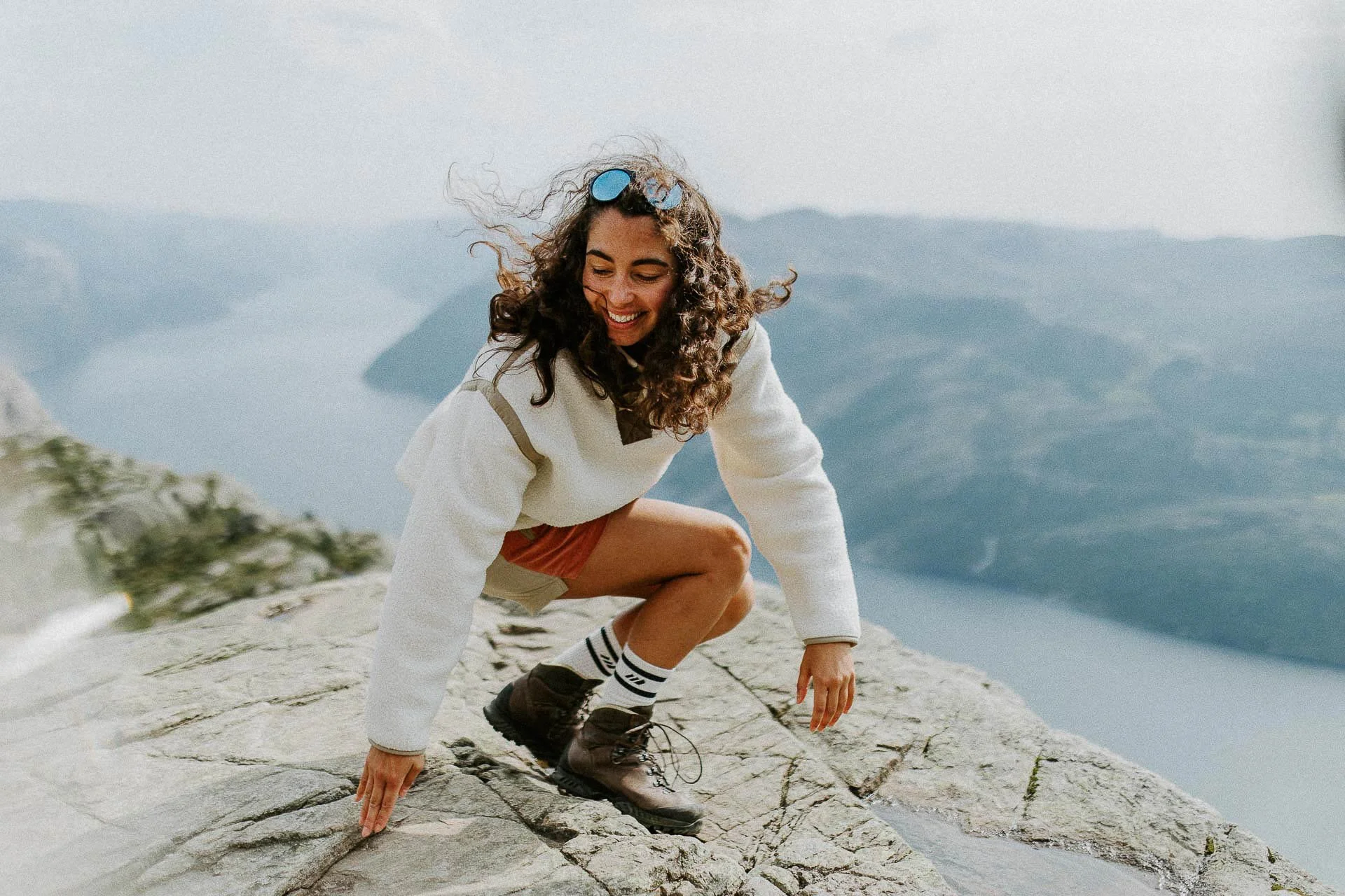 kvinne på preiekstolen i bevegelse med fjorden i bakgrunnen Reklamefotografering av modeller til kampanje for Skogstad bilder tatt i preikestolenområdet bilder av turklær
