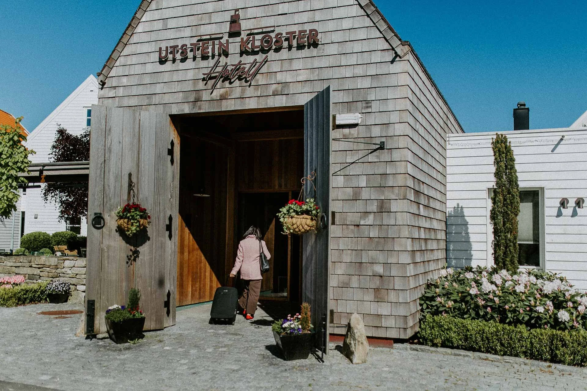 Reklamefotografering til kampanje for Altibox bedrift tatt i naturlig lys utstein kloster hotell to personer som ankommer hotellet