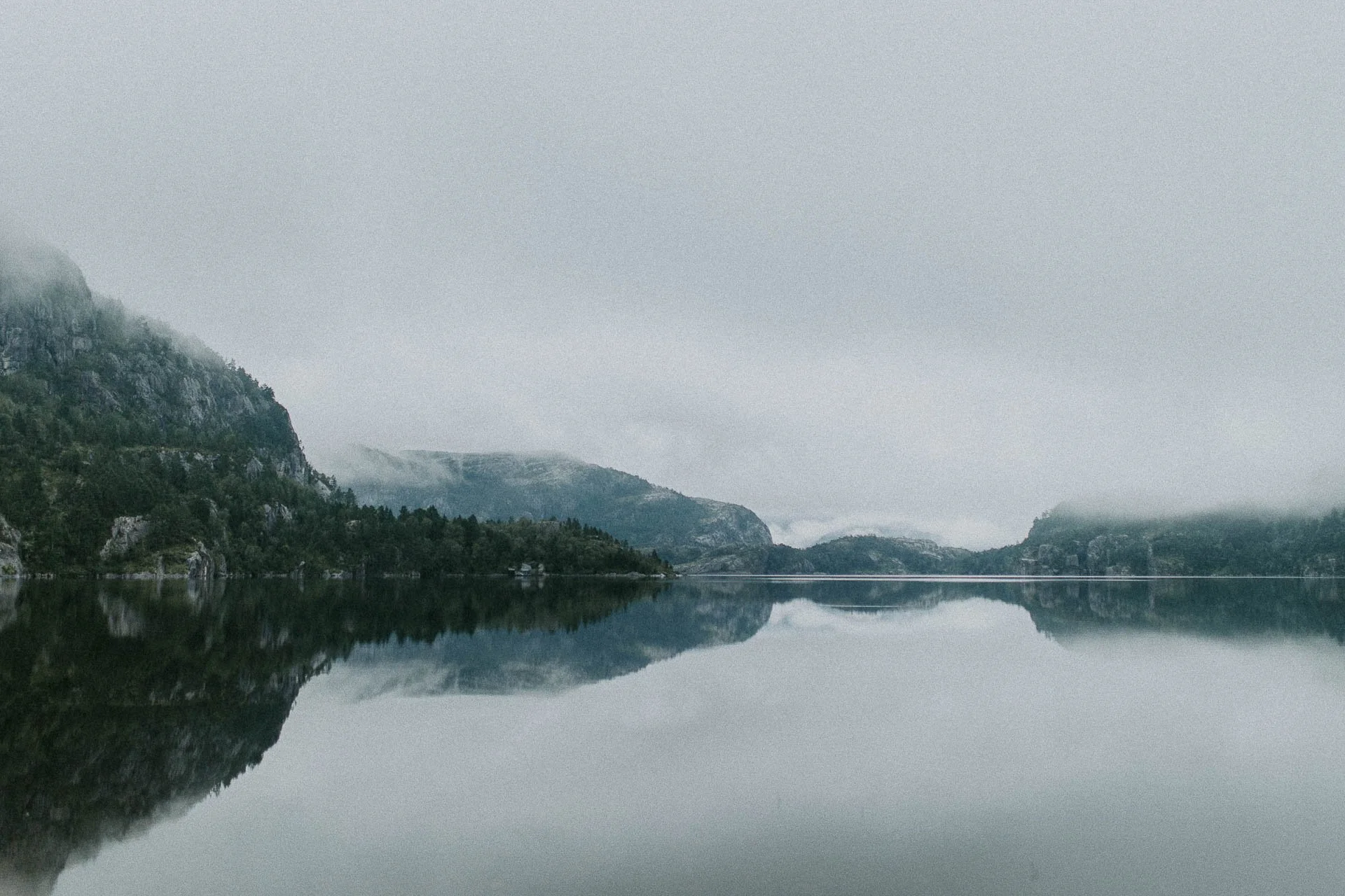 landskapsbilde av fjell og speilblankt vann Reklamefotografering til kampanje for Skogstad bilder tatt i preikestolenområdet