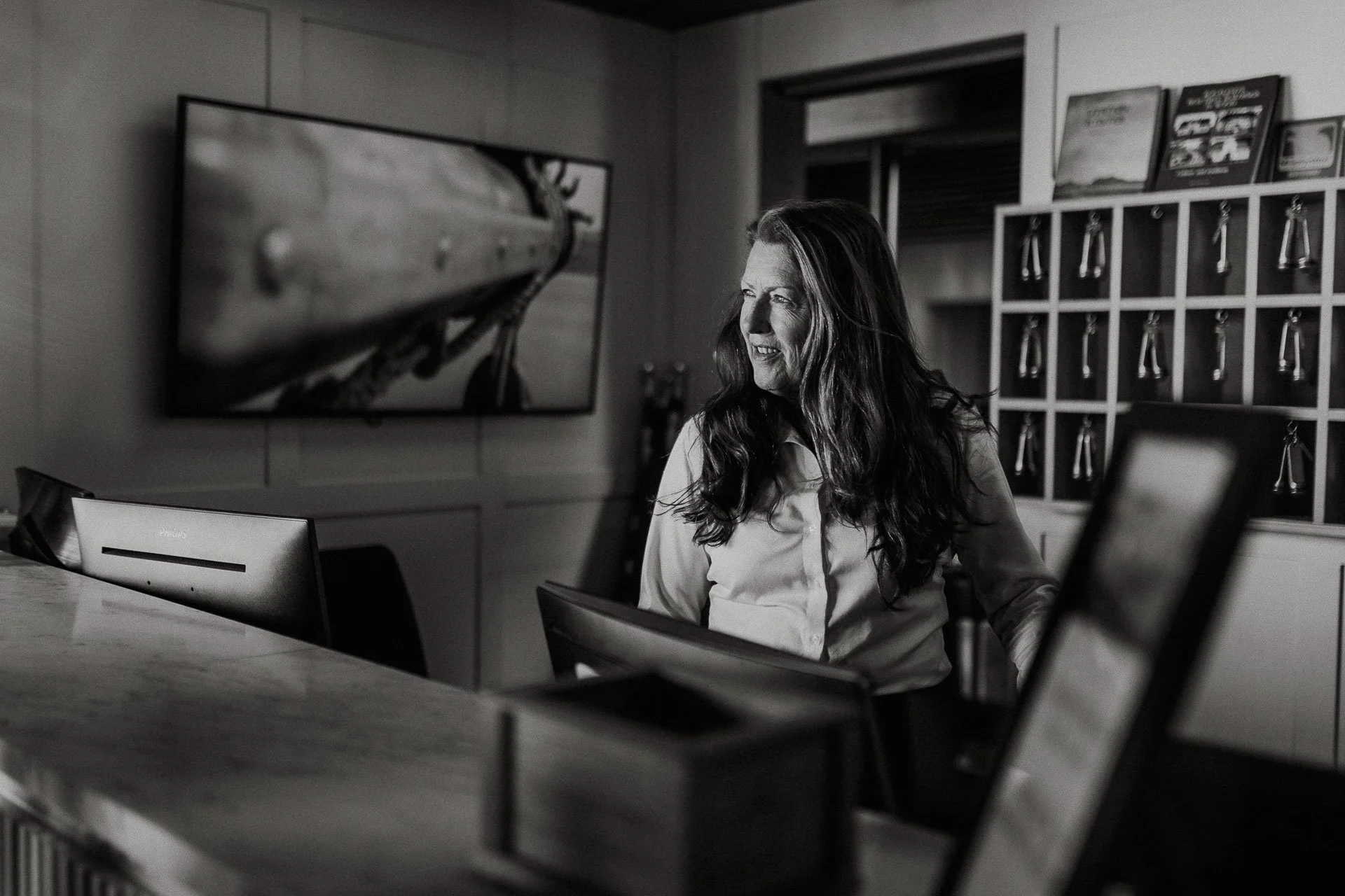 Reklamefotografering til kampanje for Altibox bedrift tatt i naturlig lys hotellansatt i skranke på utstein klosterhotell sorthvitt bilde