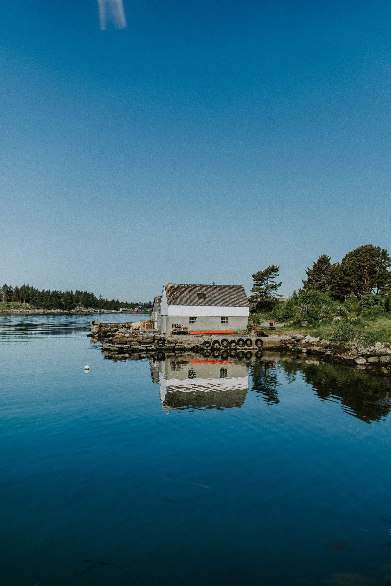 Oversiktsbilde av båt hus refleksjon av det i vann naturlig lys, reklamefotografering for stavanger kommune, områdesatsingen på kvernevik tatt på sommeren