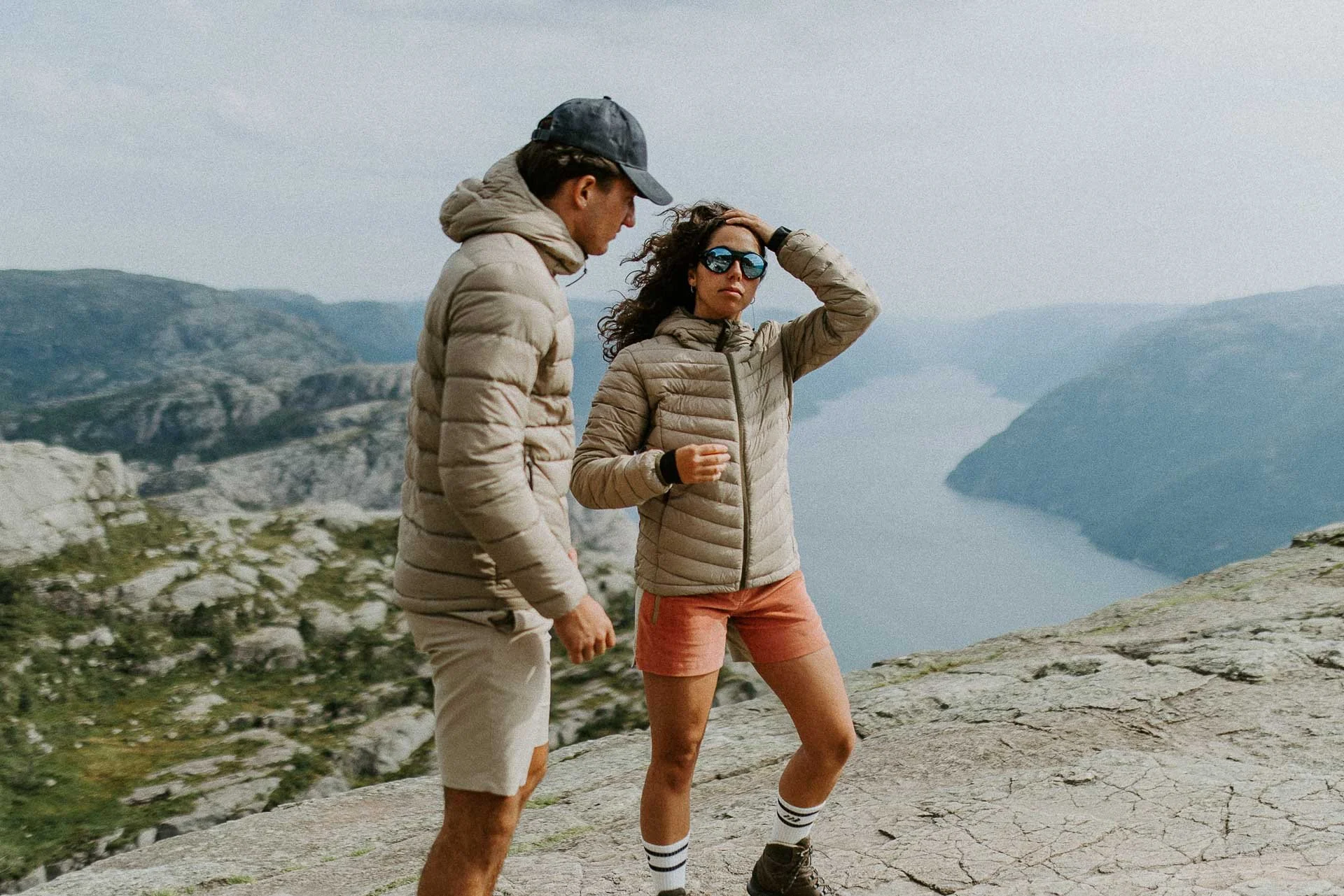 to personer på preikestolen bevegelse i hår vind solbriller på fjord i bakgreunnen Reklamefotografering av modeller til kampanje for Skogstad bilder tatt i preikestolenområdet bilder av turklær