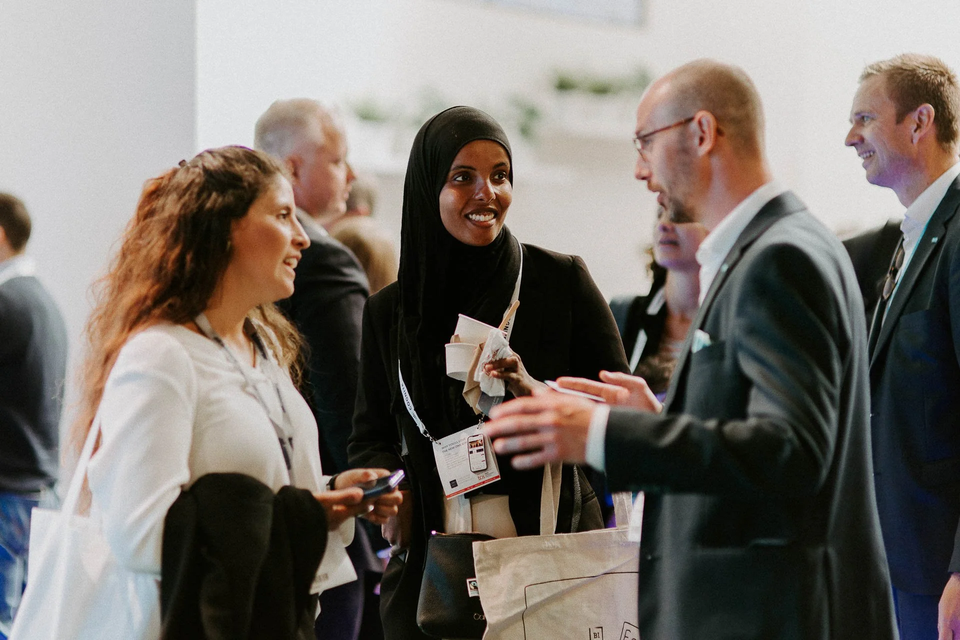 Tre stykker står i samtale to kvinner en mann mannen gestikulerer og forteller noe