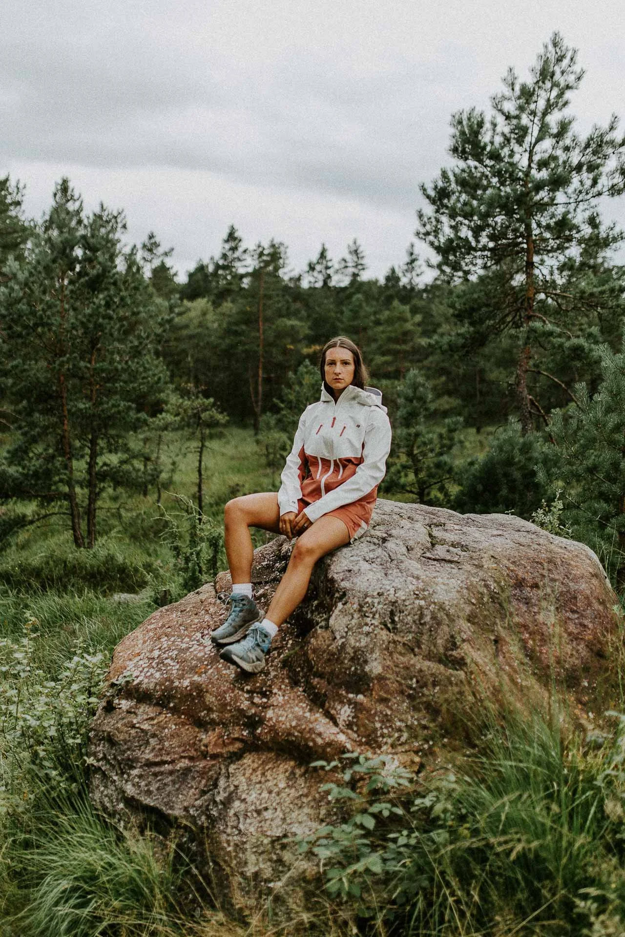 kvinne som sitter på stein og ser mot kameraet mye luft rundt modellen Reklamefotografering av modeller til kampanje for Skogstad bilder tatt i preikestolenområdet bilder av turklær