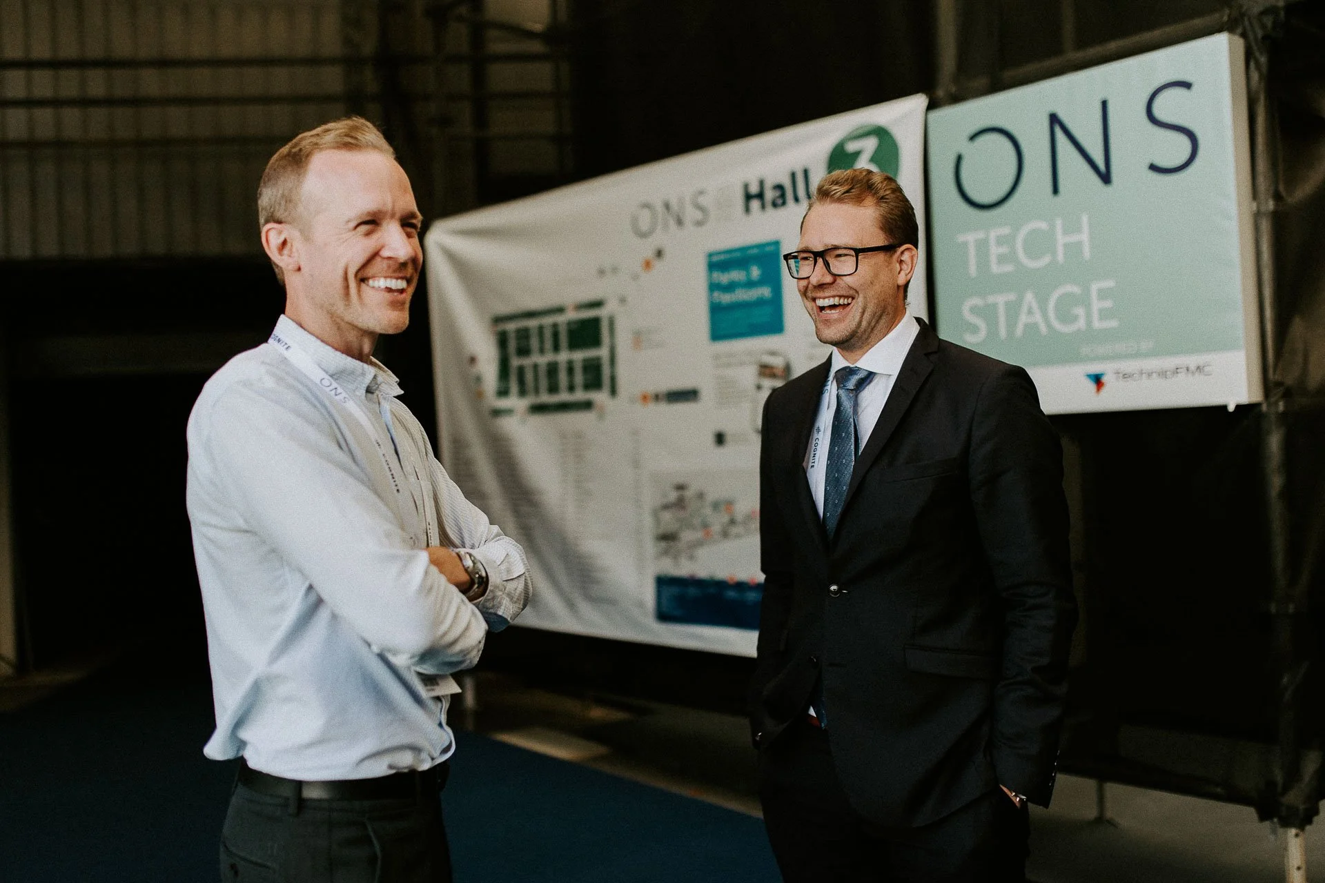 Norsk solar to menn smiler og ler halvfigur dokumentarfotografering for ONS, Offshore Northern Seas i Stavanger, stavanger forum