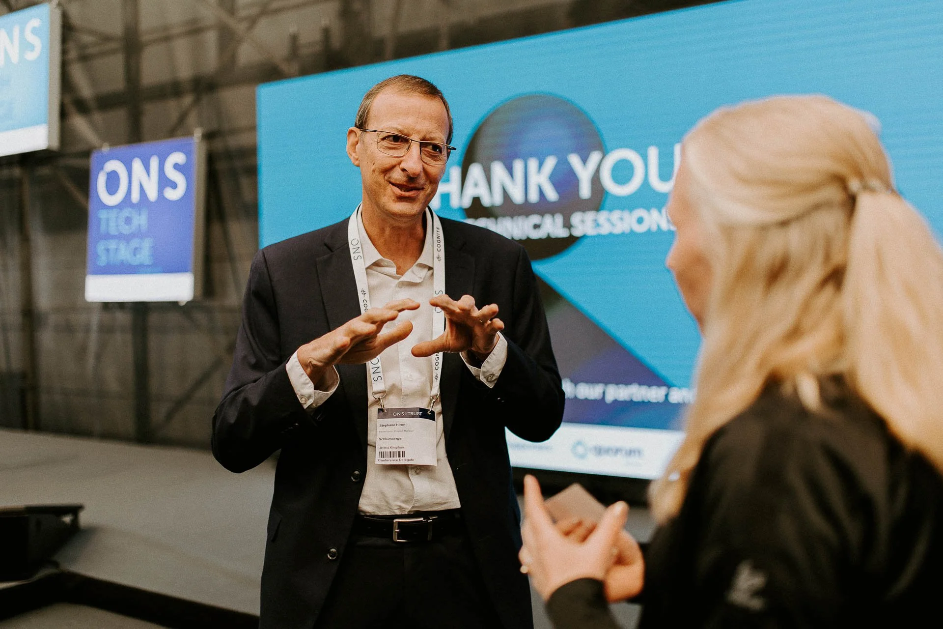 Foredragsholder i diskusjonen resirkulerer tatt ved scene med skjermer i bakgrunnen Ons logo på skjerm dokumentarfotografering for ONS, Offshore Northern Seas i Stavanger, stavanger forum