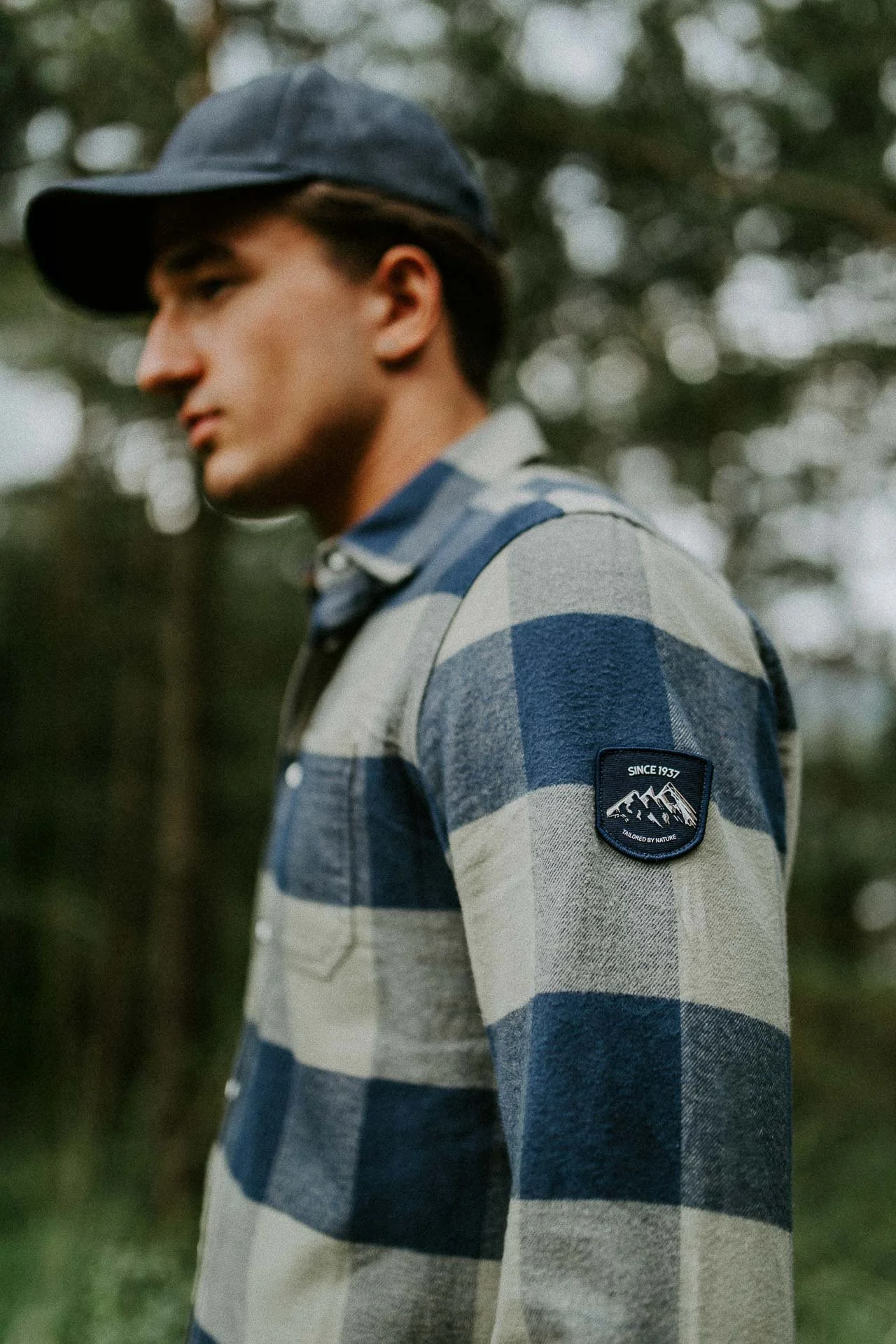 mann med skjorte på detaljebilde av logoen Reklamefotografering av modeller til kampanje for Skogstad bilder tatt i preikestolenområdet bilder av turklær