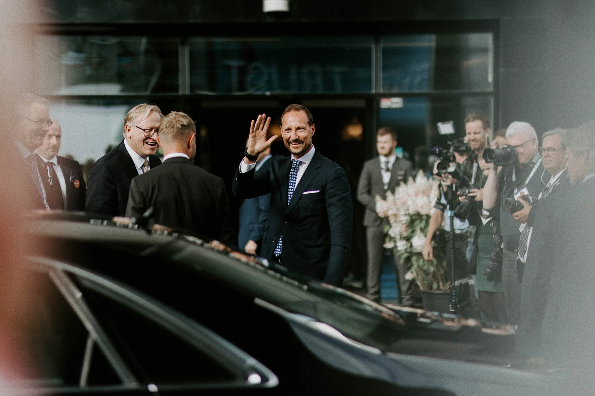 Kronprins Haakon på vei inn til Ons han vinker og smiler mange andre folk i Bakgrunn som smiler en bil i forgrunnen dokumentarfotografering for ONS, Offshore Northern Seas i Stavanger, stavanger forum