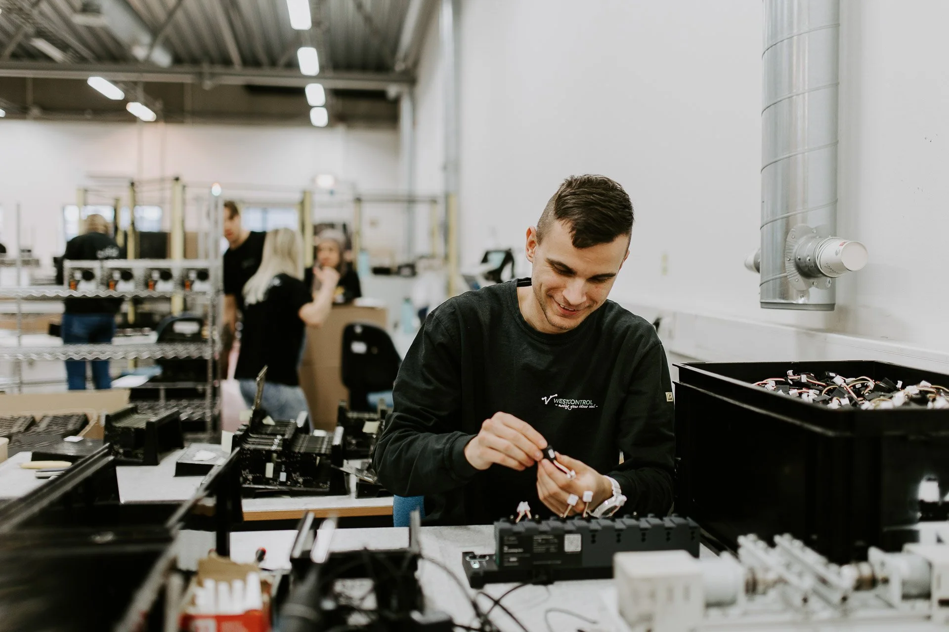 Mann i arbeid med verkstedet i bakgrunnen fotografering for zaptec til kampanjebruk og presse naturlig lys verksted westcontrol