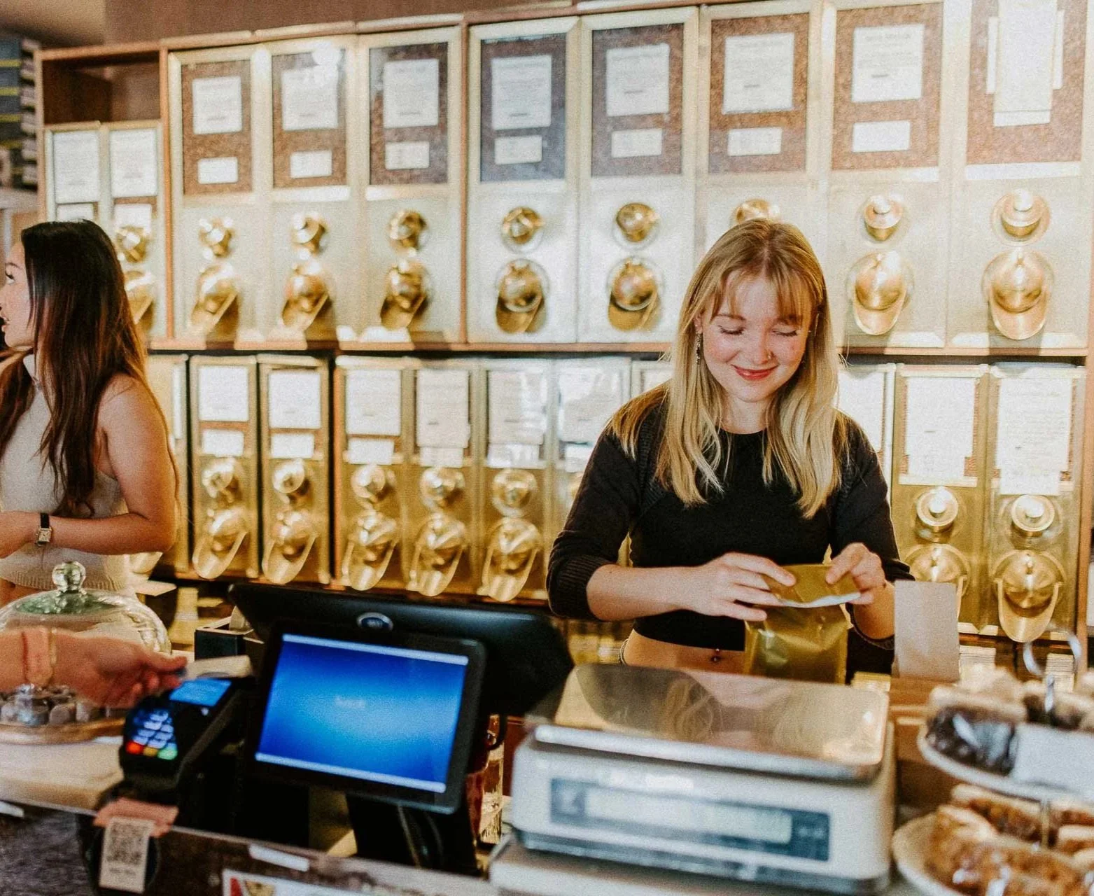 Reklamefotografering til kampanje for Altibox bedrift tatt i naturlig lys salg av kaffe ei som står i kassen ved kassapparat gjør klar bestilling