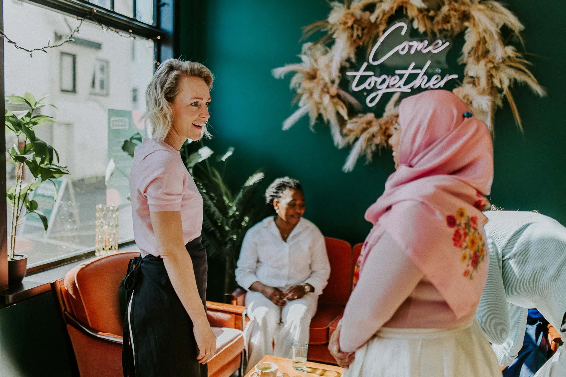 Bildene for Frænd som viser ansatte i arbeid, miljøet rundt dem og maten som serveres. naturlig lys