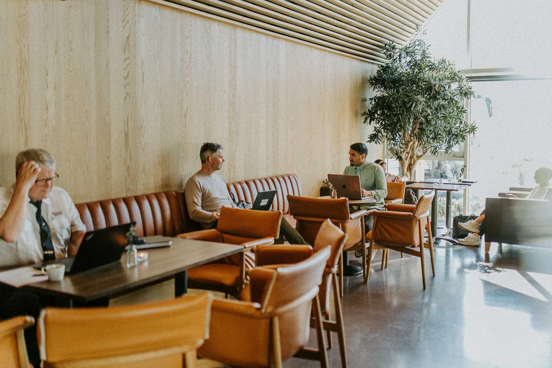 Reklamefotografering til kampanje for Altibox bedrift tatt i naturlig lys utstein kloster hotell to som jobber på pc i restaurant møtesituasjon motlys