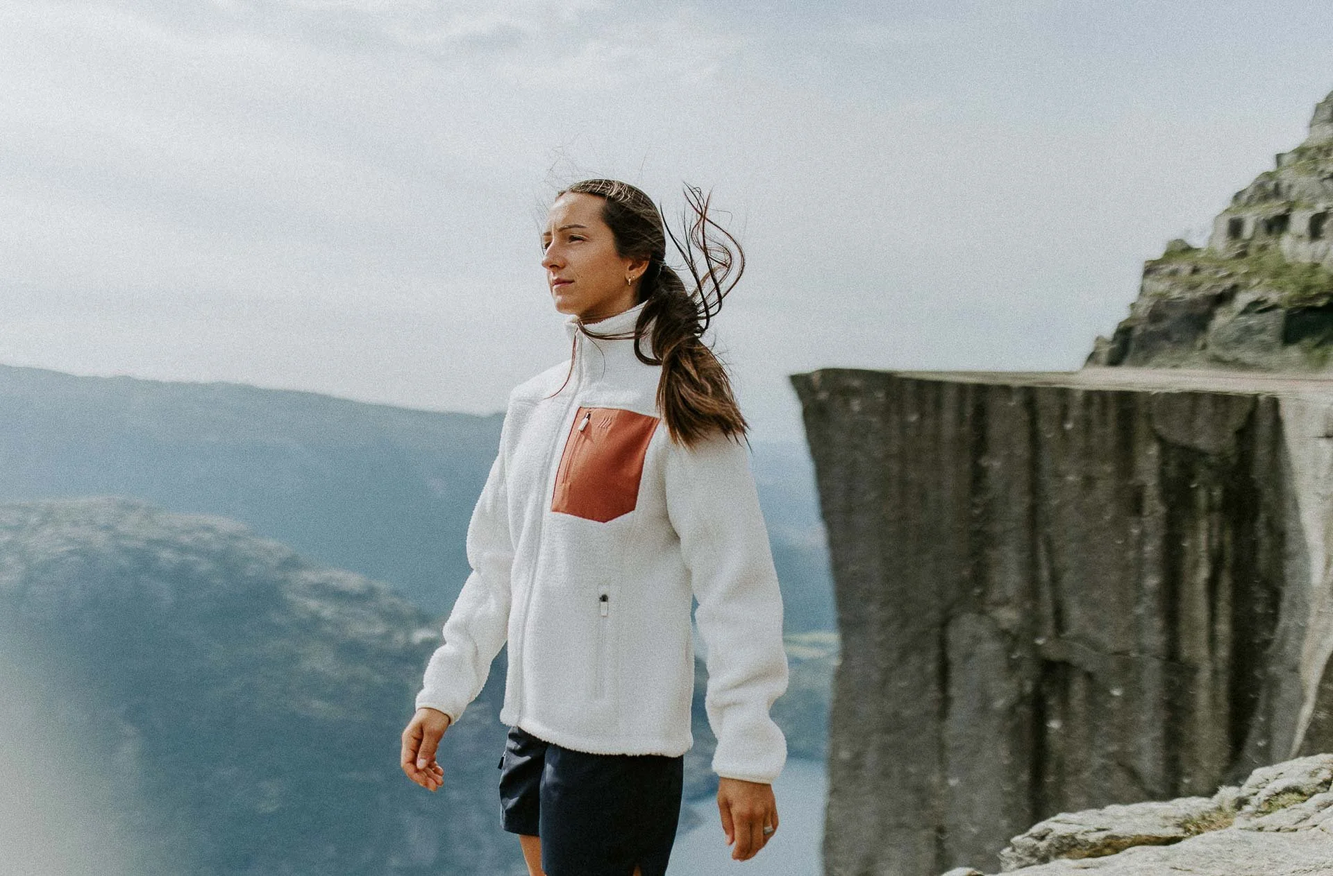  kvinne som står med preikestolen i bakgrunnen vind i hår Reklamefotografering til kampanje for Skogstad bilder tatt i preikestolenområdet bilder av turklær