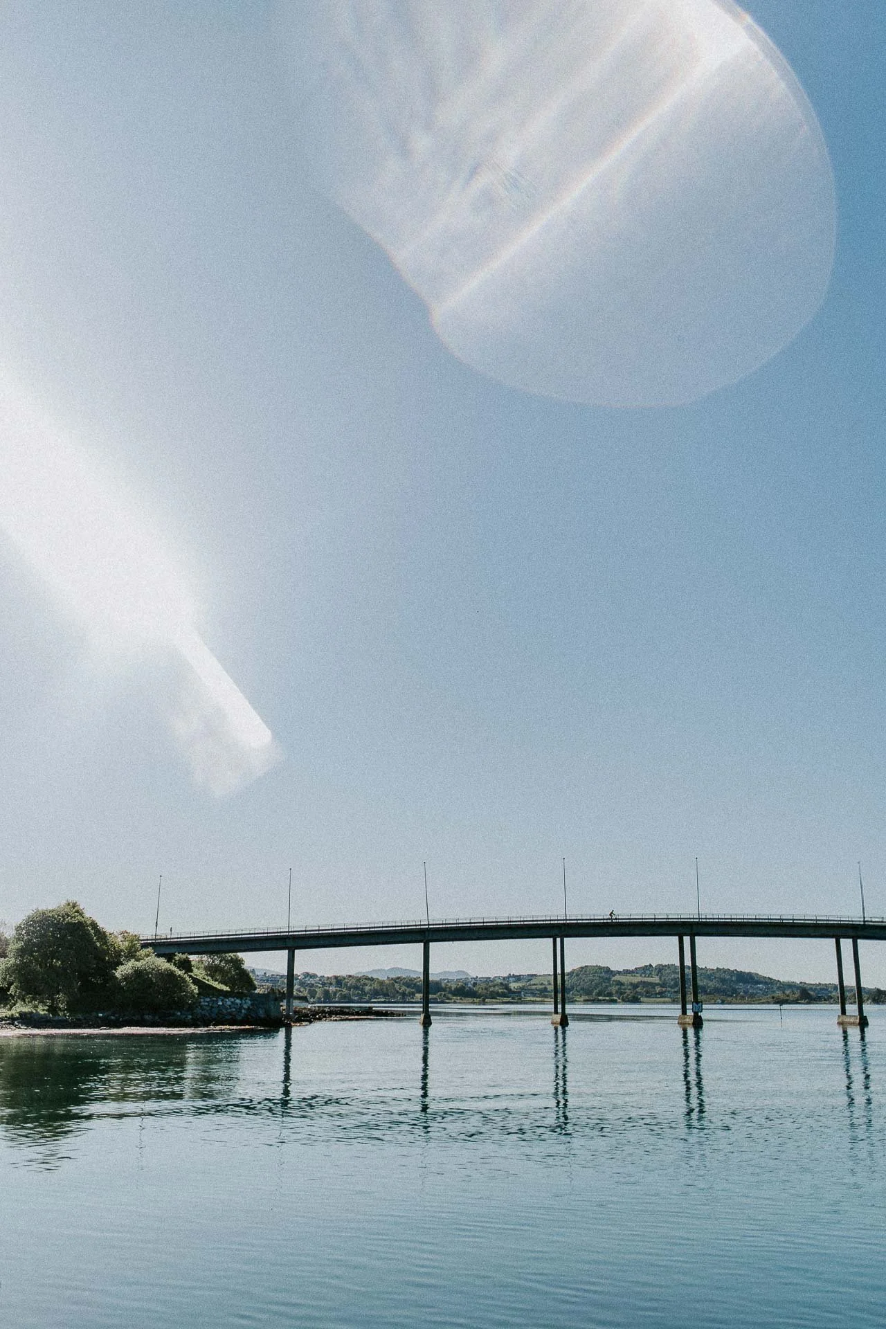 Bro og person som sykler over broen prisme bruk refleksjon av bro i vann naturlig lys, reklamefotografering for stavanger kommune, områdesatsingen på kvernevik tatt på sommeren