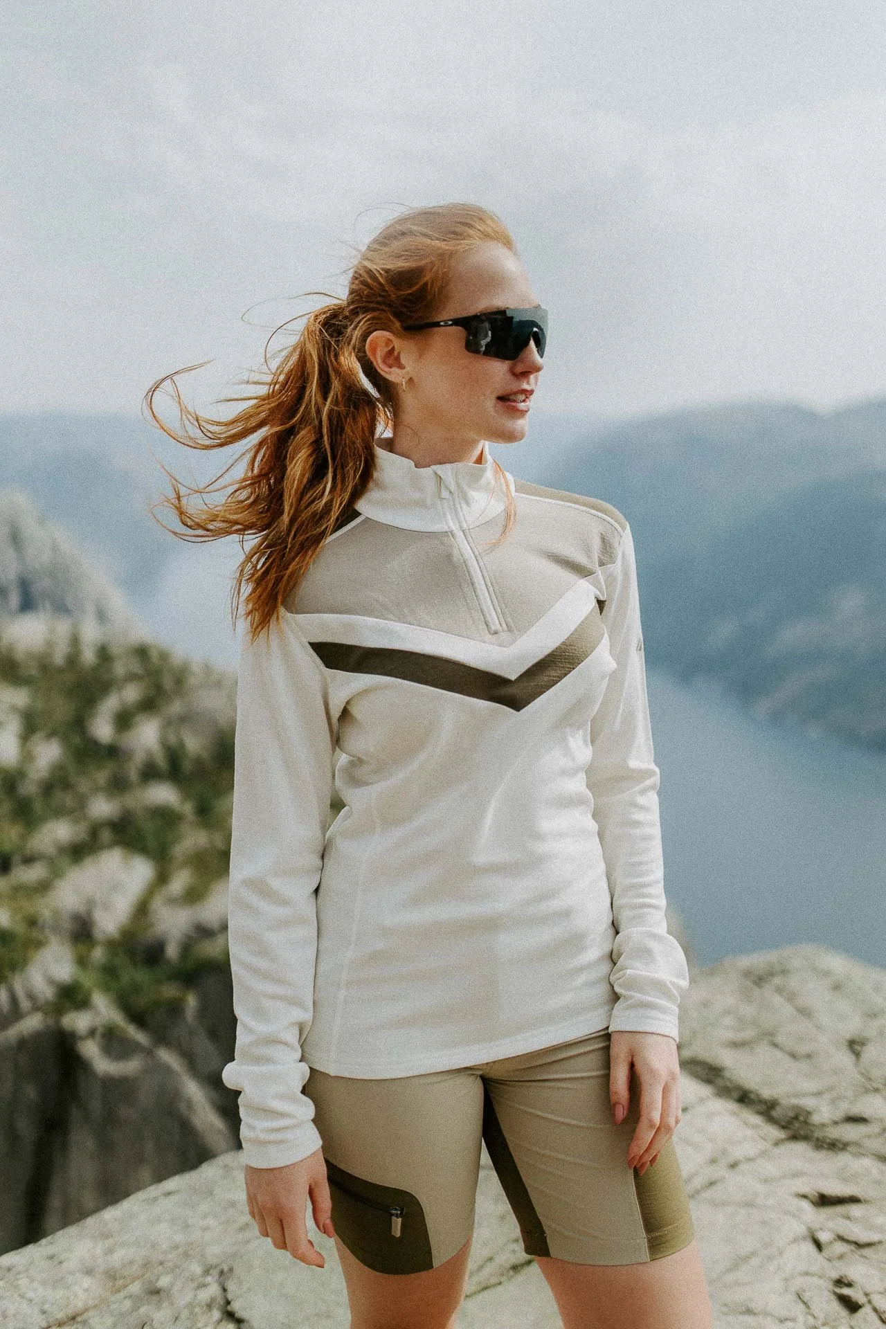 Kvinne på preikestolen med fjorden i bakgrunnen solbriller på Reklamefotografering av modeller til kampanje for Skogstad bilder tatt i preikestolenområdet bilder av turklær