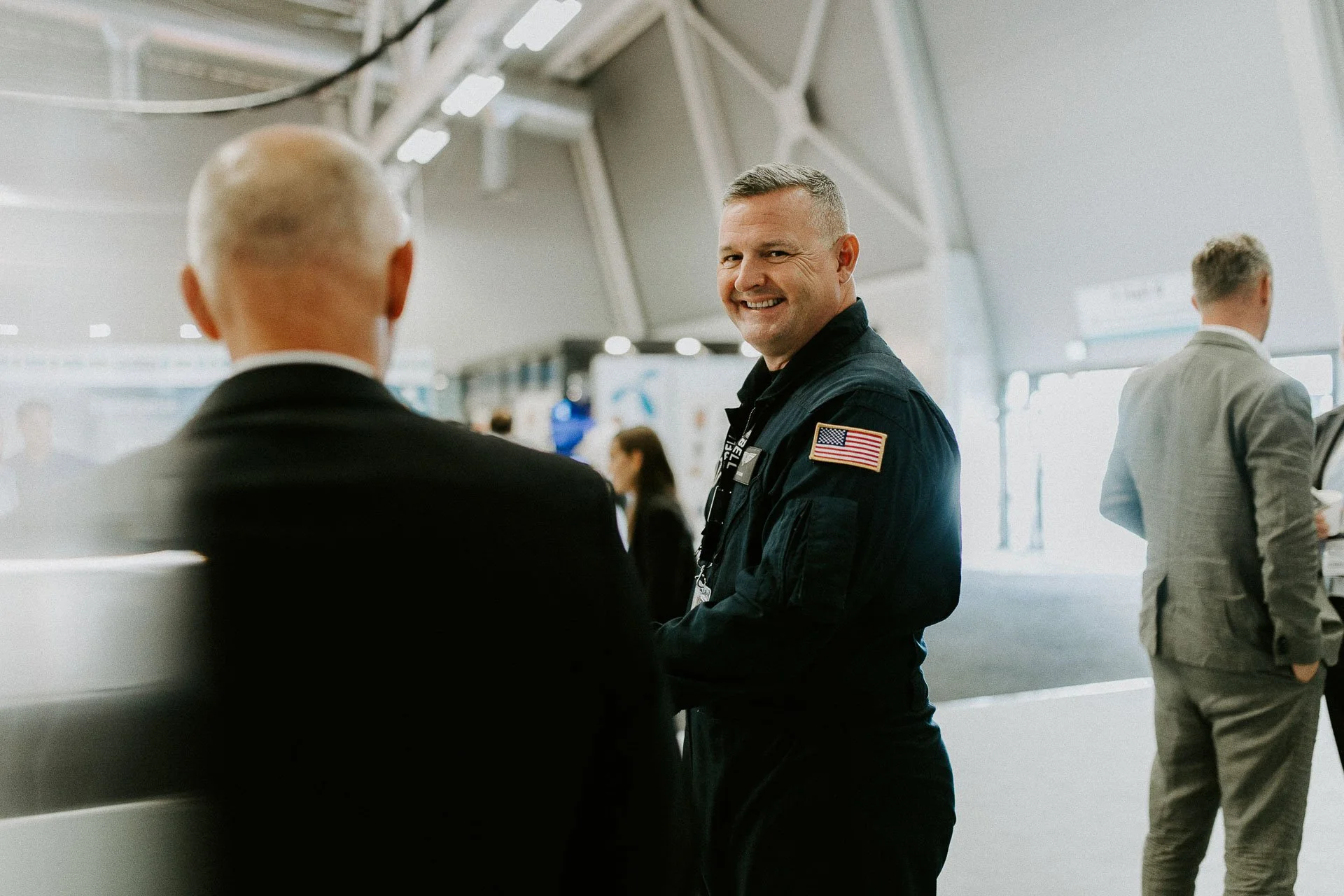 Mannen som smiler og ser i kameraet har på fly drakt dokumentarfotografering for ONS, Offshore Northern Seas i Stavanger, stavanger forum