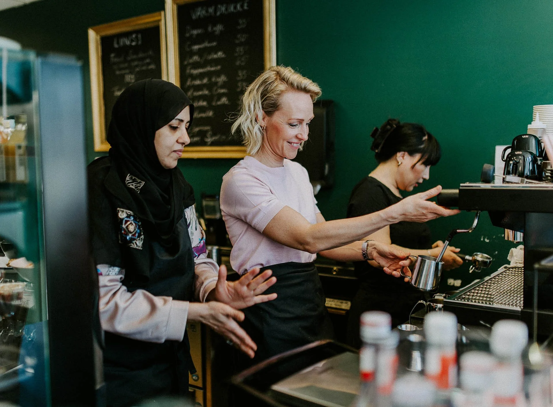Bildene for Frænd som viser ansatte i arbeid, miljøet rundt dem og maten som serveres. naturlig lys