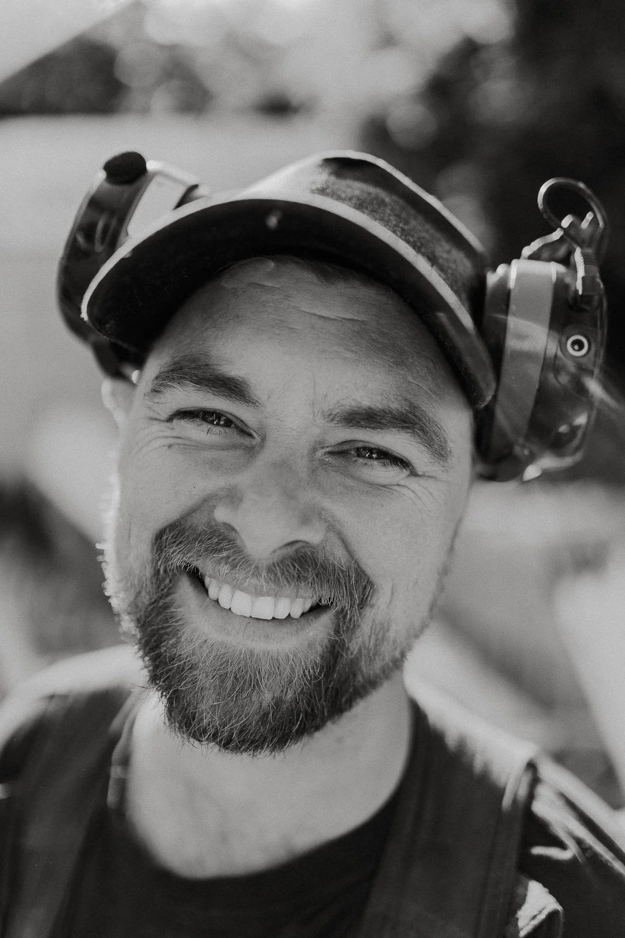 Reklamefotografering til kampanje for Altibox bedrift tatt i naturlig lys bilde av tømrer som er i arbeidssituasjon pusser opp hus sorthvitt portrett tømrer ser i kameraet