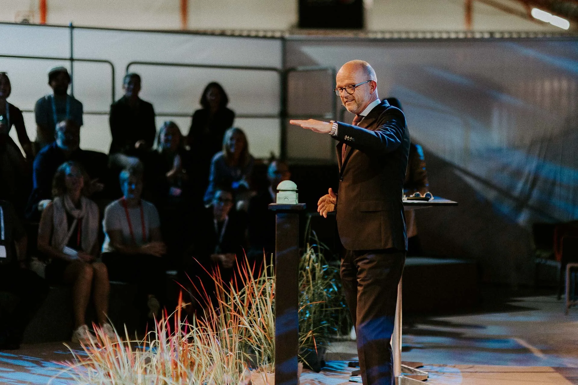 En mann skal til å trykke på en stor knapp han står på scenen smiler man ser publikum i mørket i bakgrunnen dokumentarfotografering for ONS, Offshore Northern Seas i Stavanger, stavanger forum