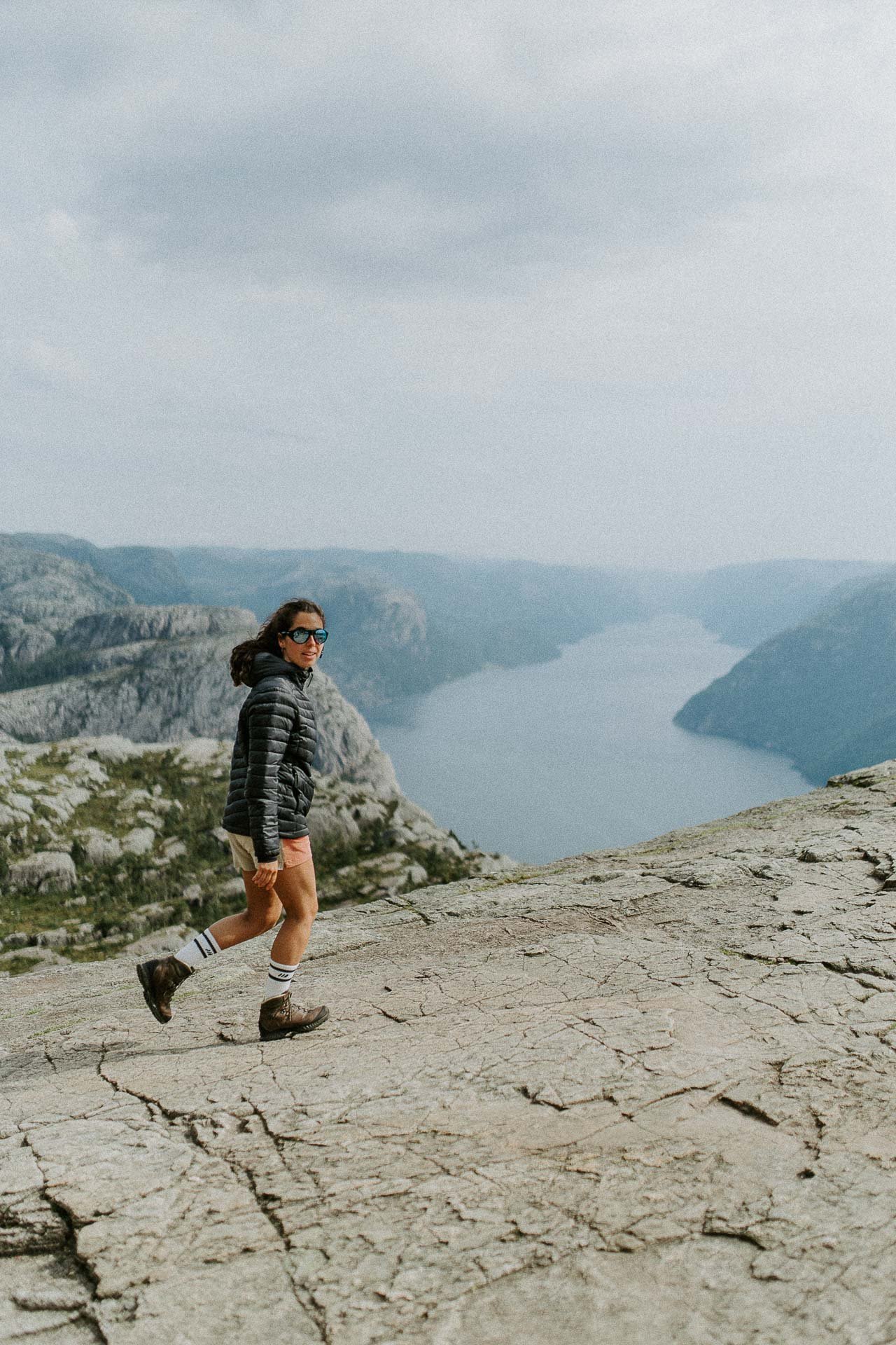 kvinne som går på preikestolen fjorden i bakgrunnen Reklamefotografering av modeller til kampanje for Skogstad bilder tatt i preikestolenområdet bilder av turklær