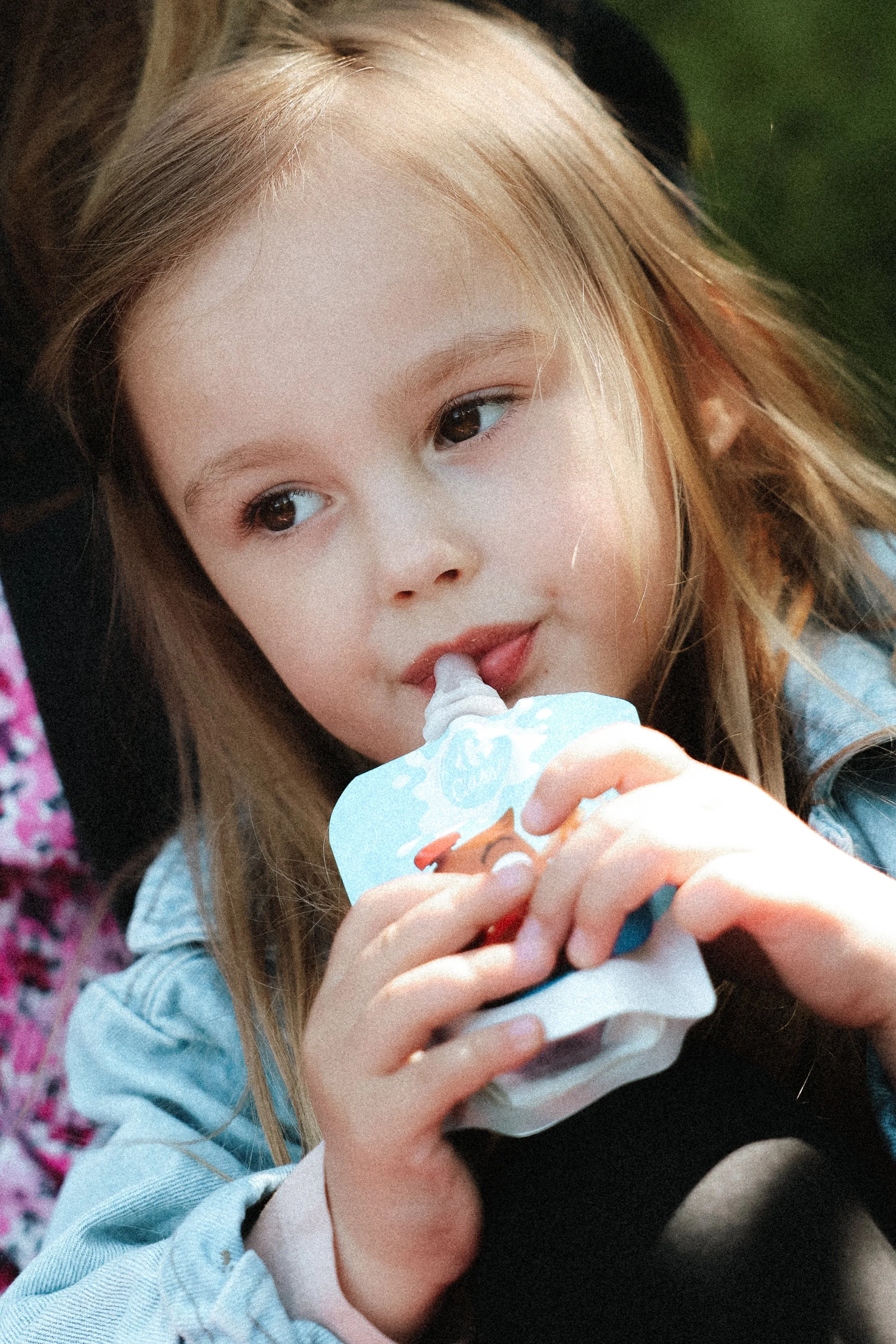 Jeune fille blonde qui mange une glace.