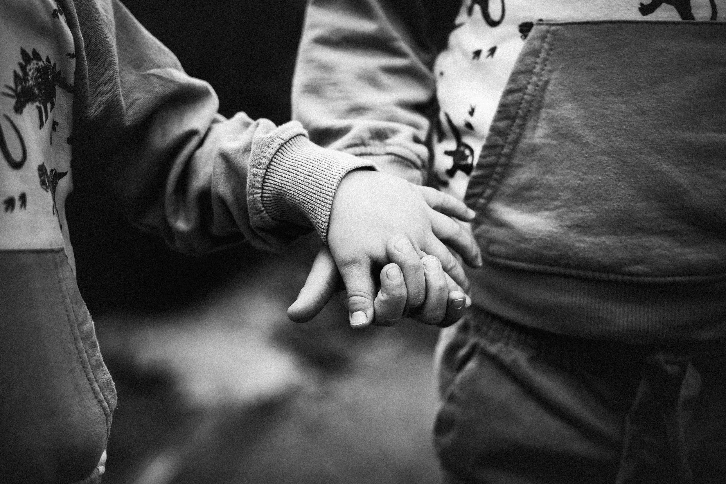 Deux enfants tenant la main, en noir et blanc.