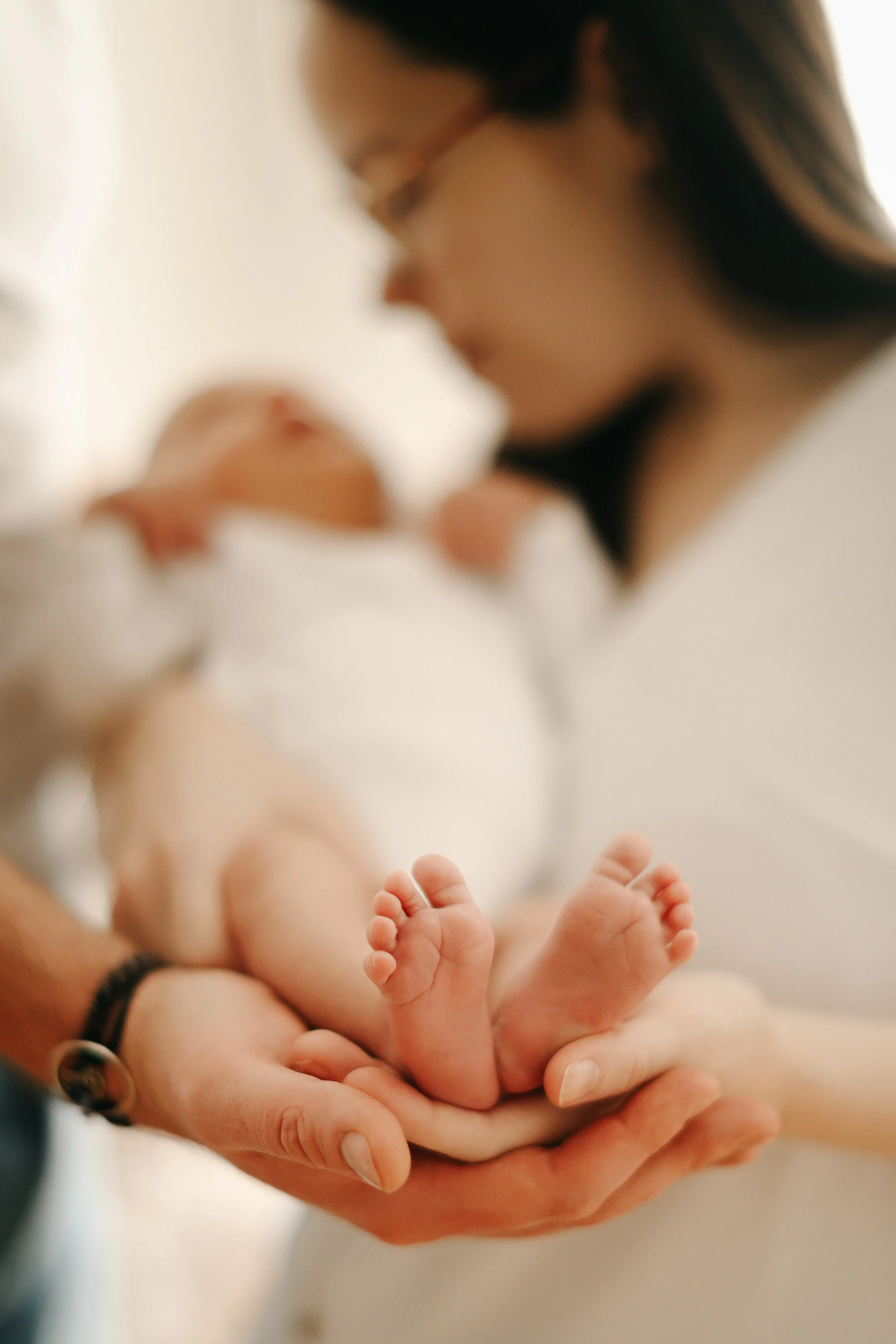Une personne tenant doucement un bébé, mettant en valeur la petite taille et la tendresse.