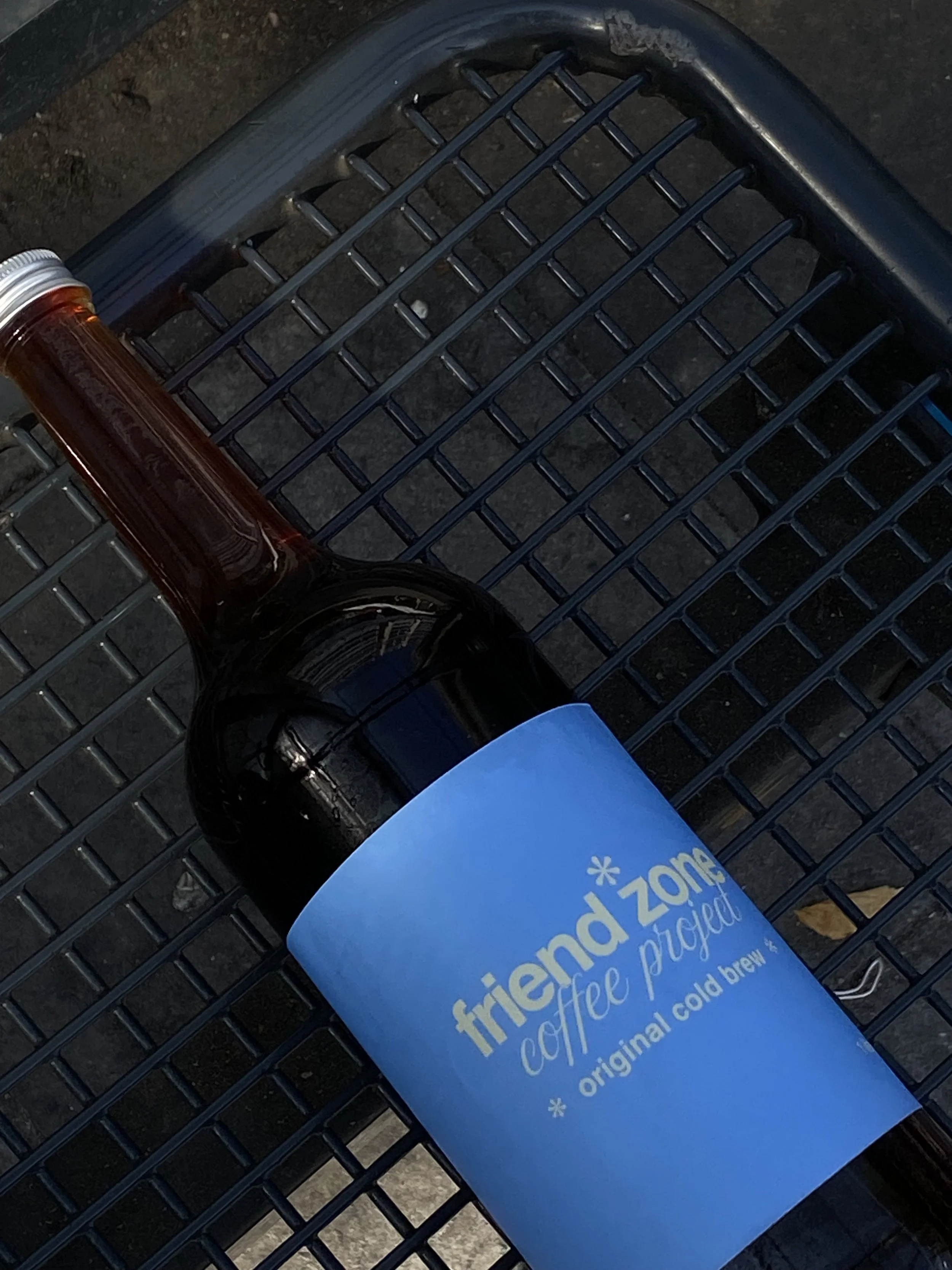 A bottle of cold brew coffee with a blue label on a shopping cart.
