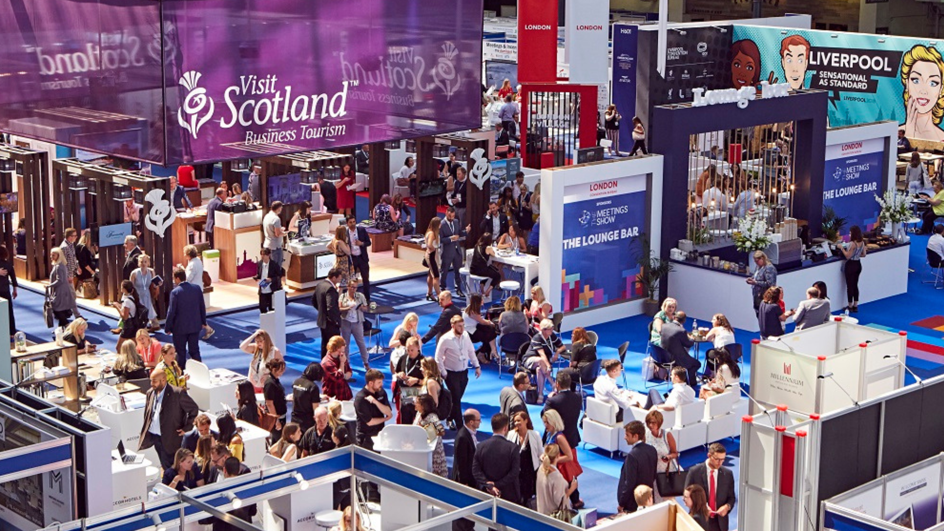 Crowd of people at a trade show with various booths and displays