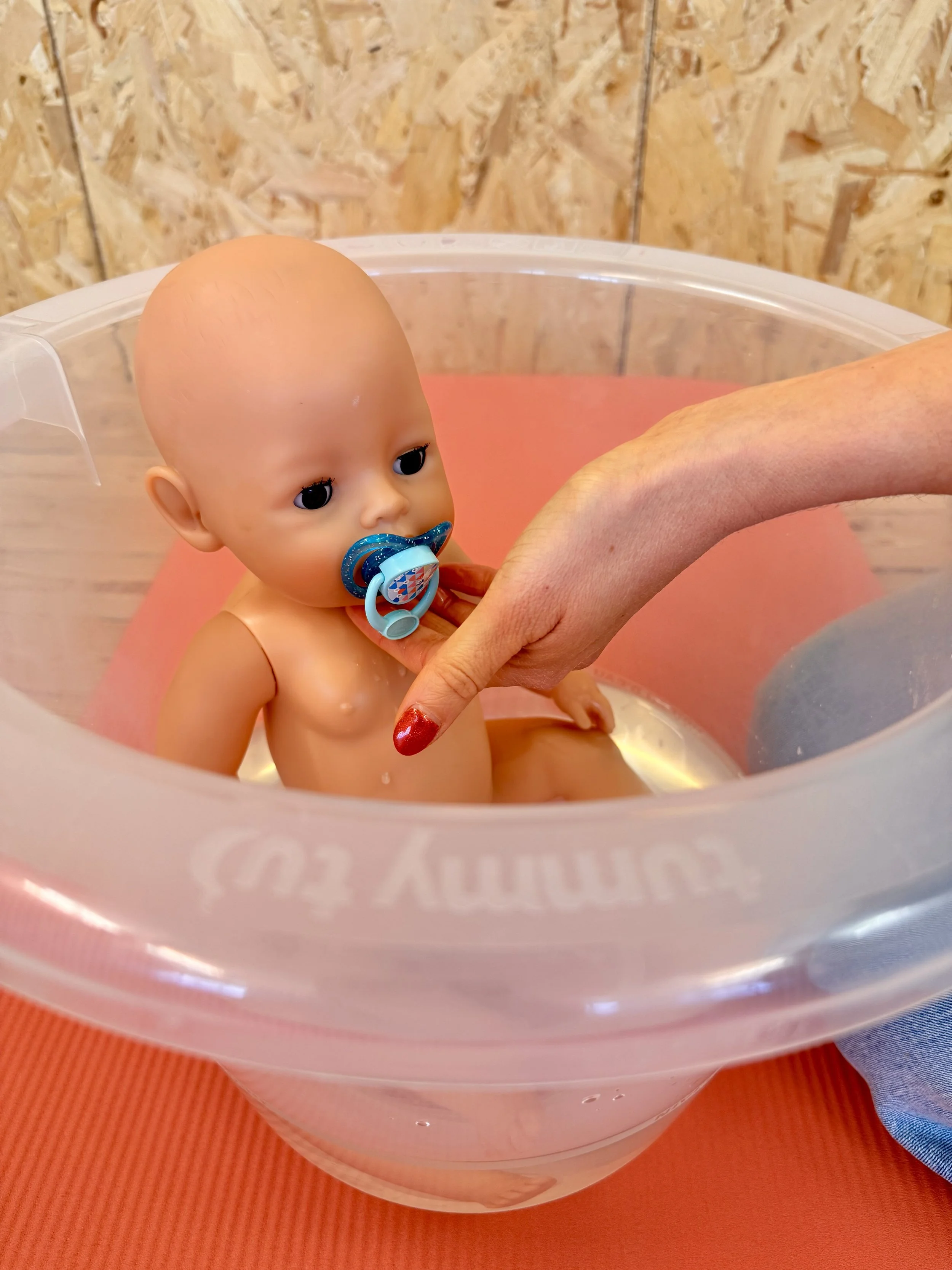 Oefenpop in een kinderbadje, gebruikt als demonstratiemateriaal tijdens workshops babymassage en babygymnastiek in Gent.
