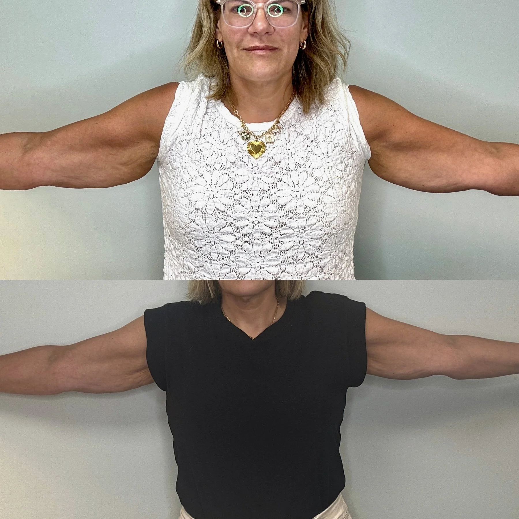 A woman with glasses and earrings stands against a plain background with her arms extended to the sides, showing her muscular arms.