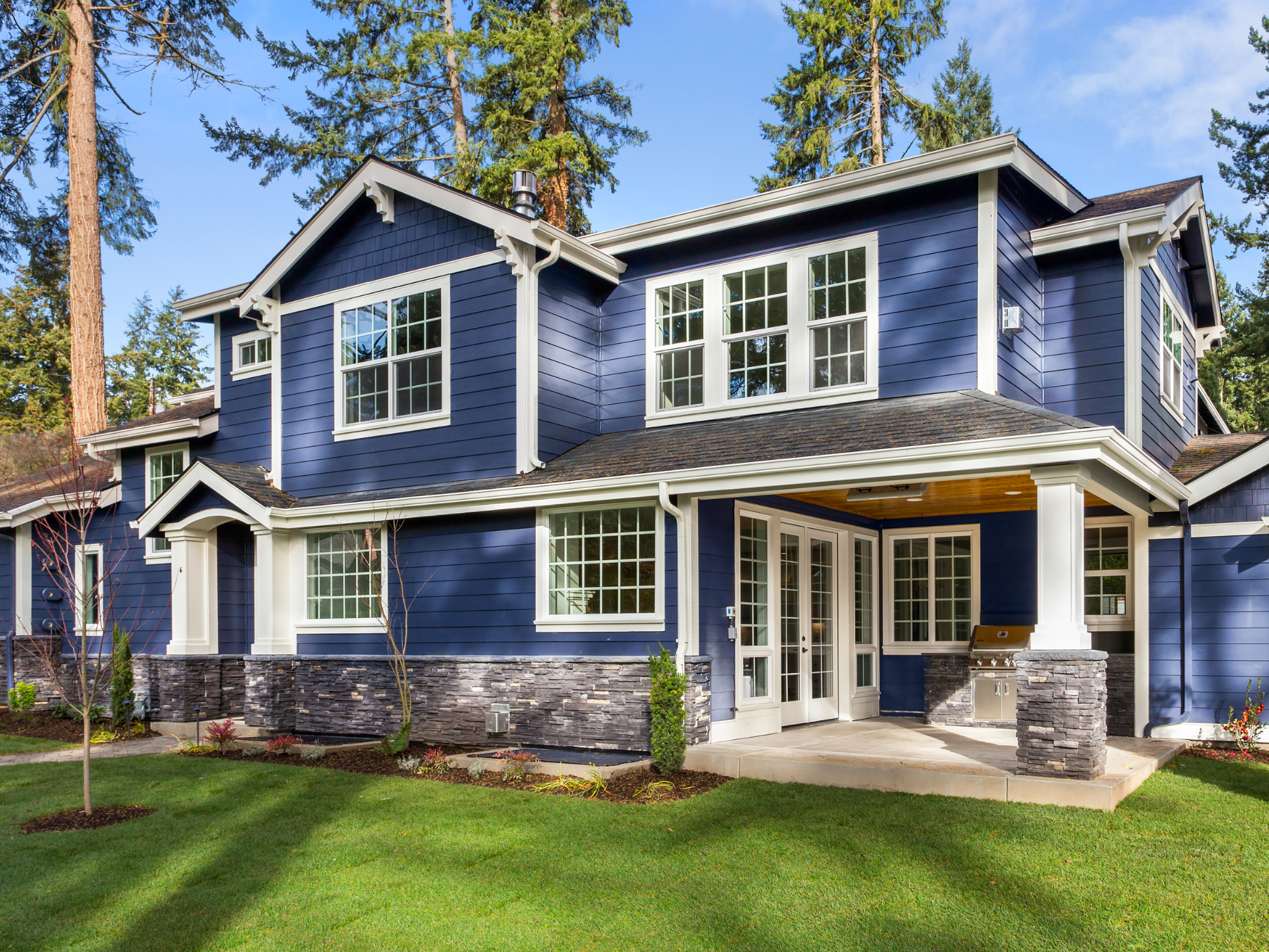 This home with blue siding has beautiful windows.