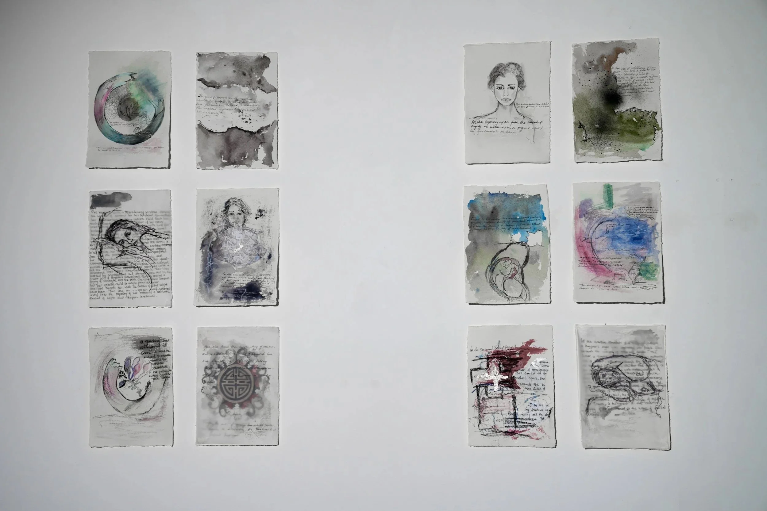 A collection of 12 artistic illustrations and sketches displayed on a white wall, arranged in 3 rows and 4 columns. The artwork features watercolor paintings, sketches of people, abstract designs, and handwritten notes.
