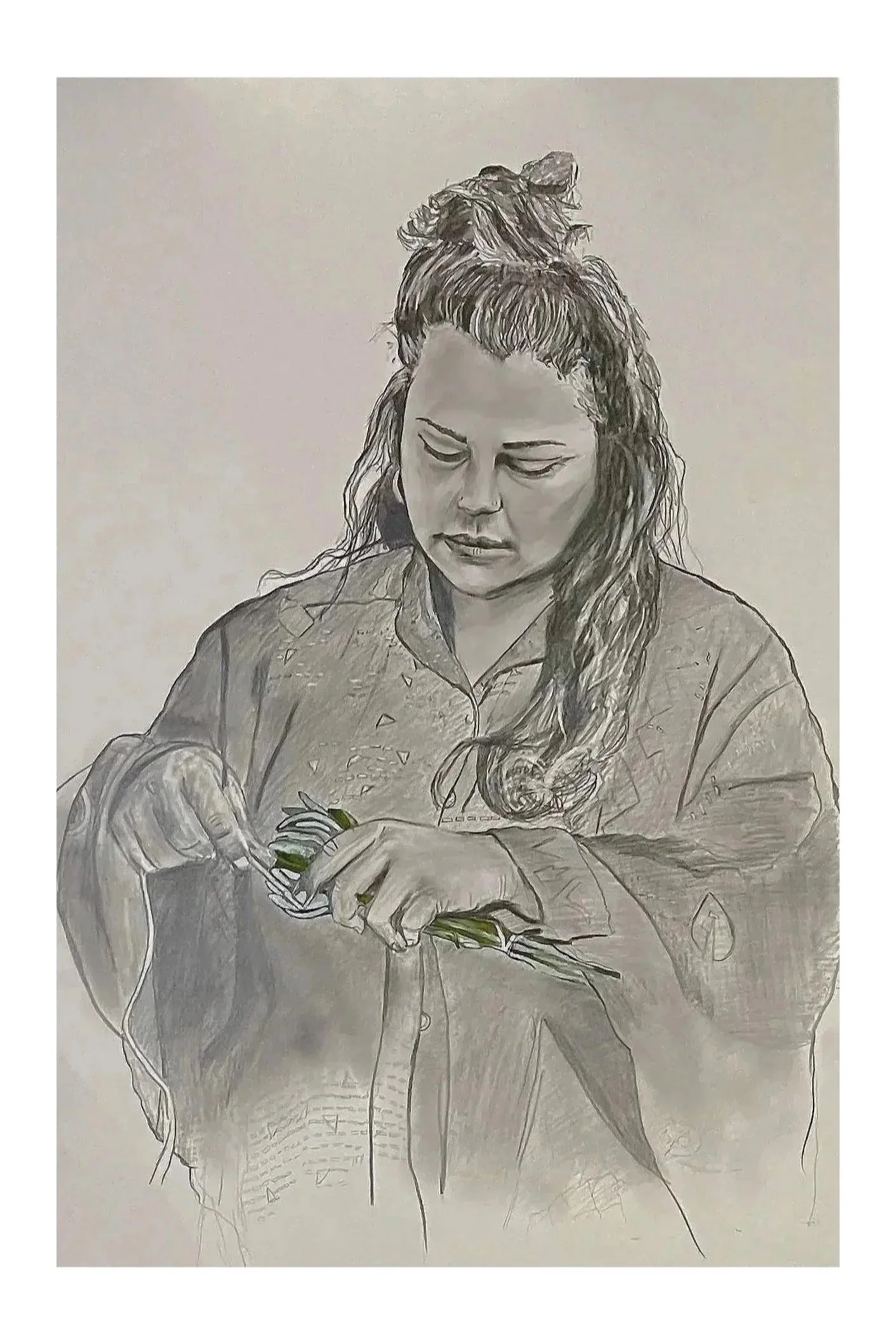 A woman with wavy hair and bangs, wearing a button-up shirt, is focused on knitting with green yarn, holding knitting needles.