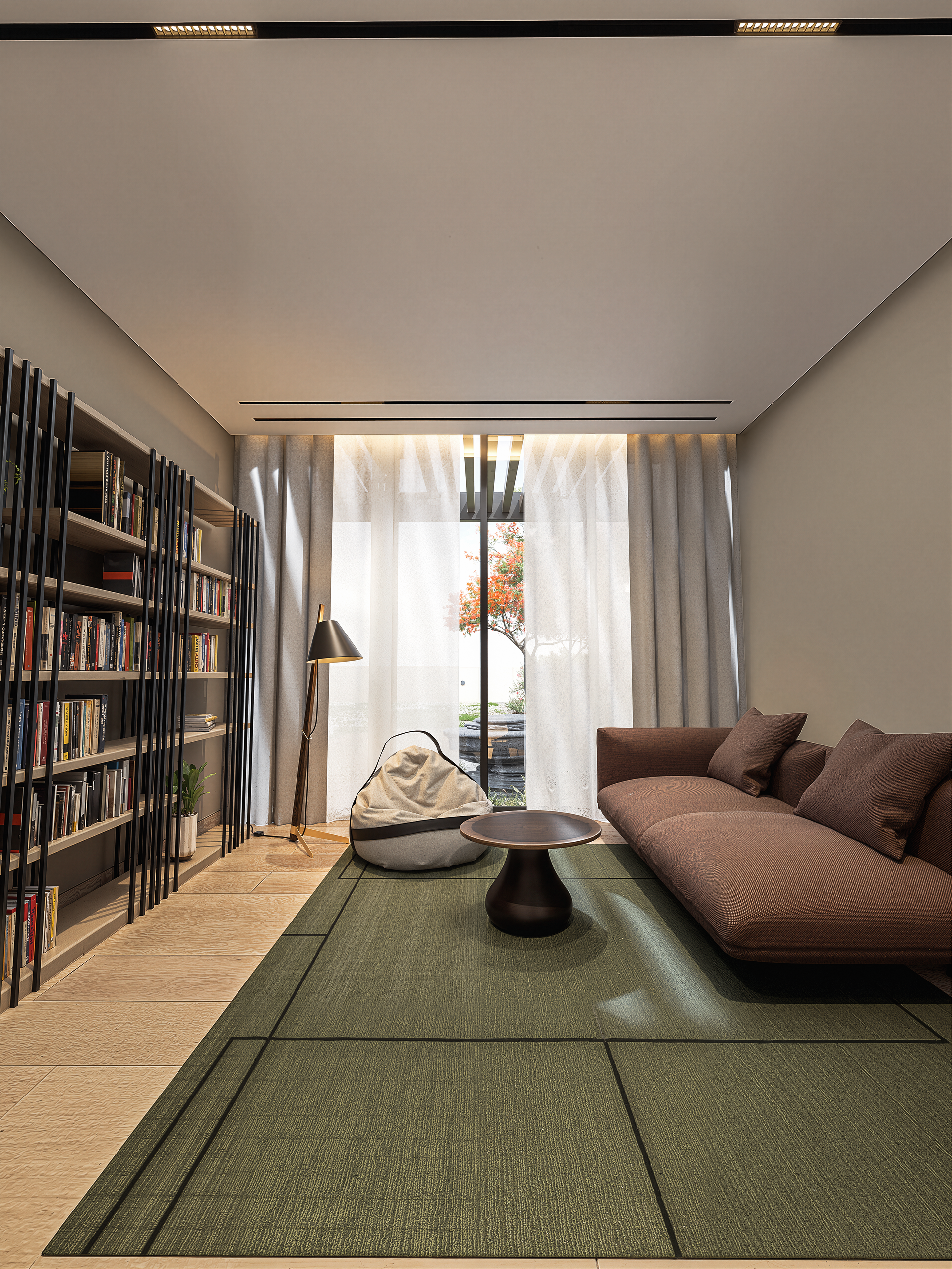 Modern living room with a brown sofa, green area rug, black round coffee table, white bean bag chair, and a tall bookshelf with books on the left side. Large window with white curtains and sheer drapes, a floor lamp, and a view of trees outside.