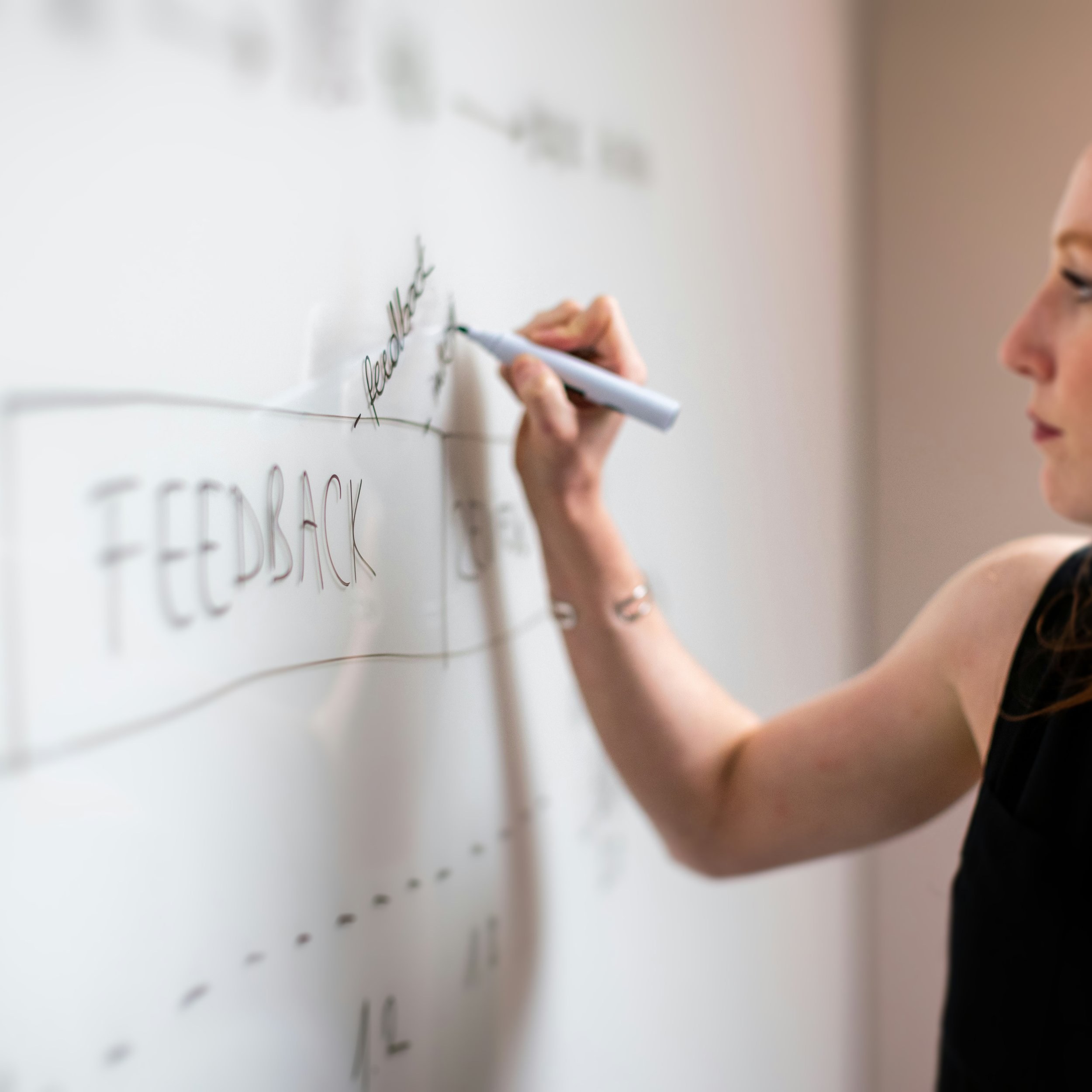 Frau schreibt während eines Seminars zu psychologischen Themen an ein Whiteboard.