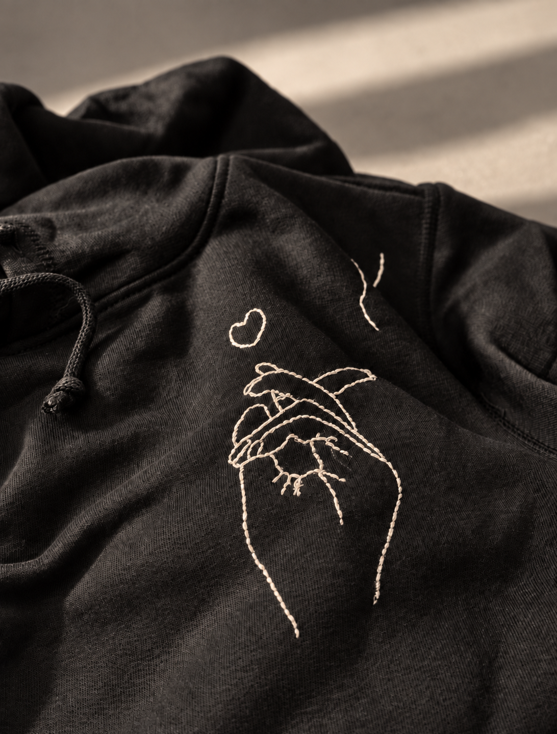 Hoodie brodé, main et fumée.png