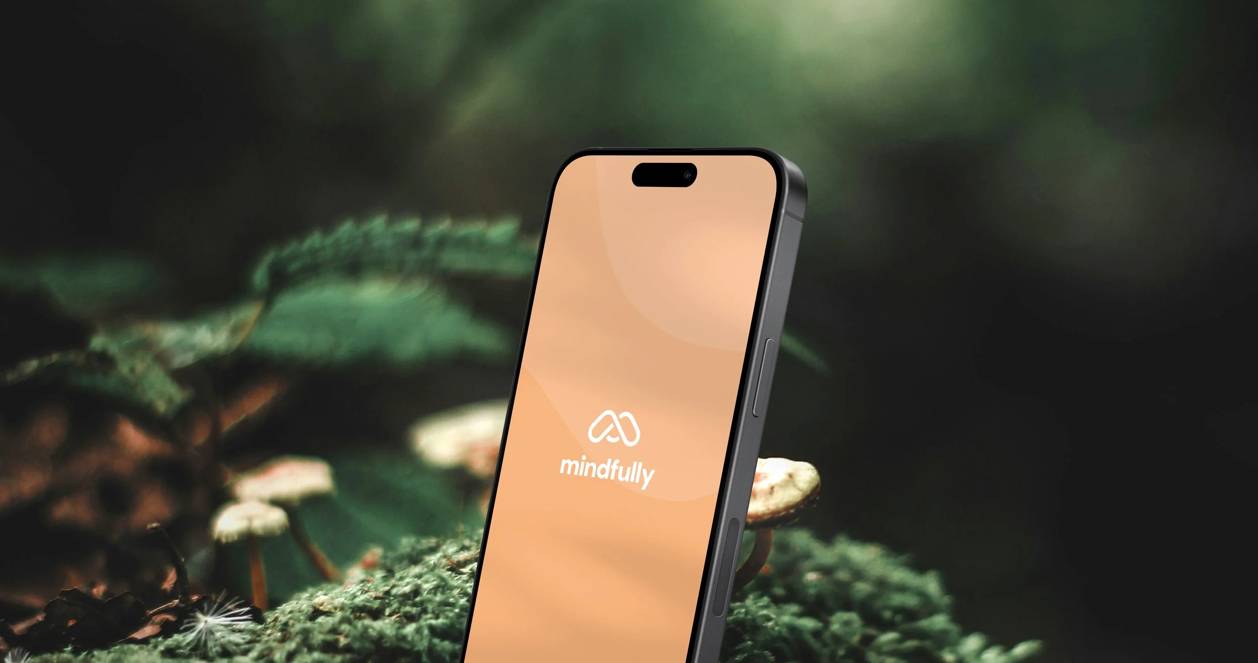 A smartphone displaying the 'mindfully' app against a blurred green nature background.