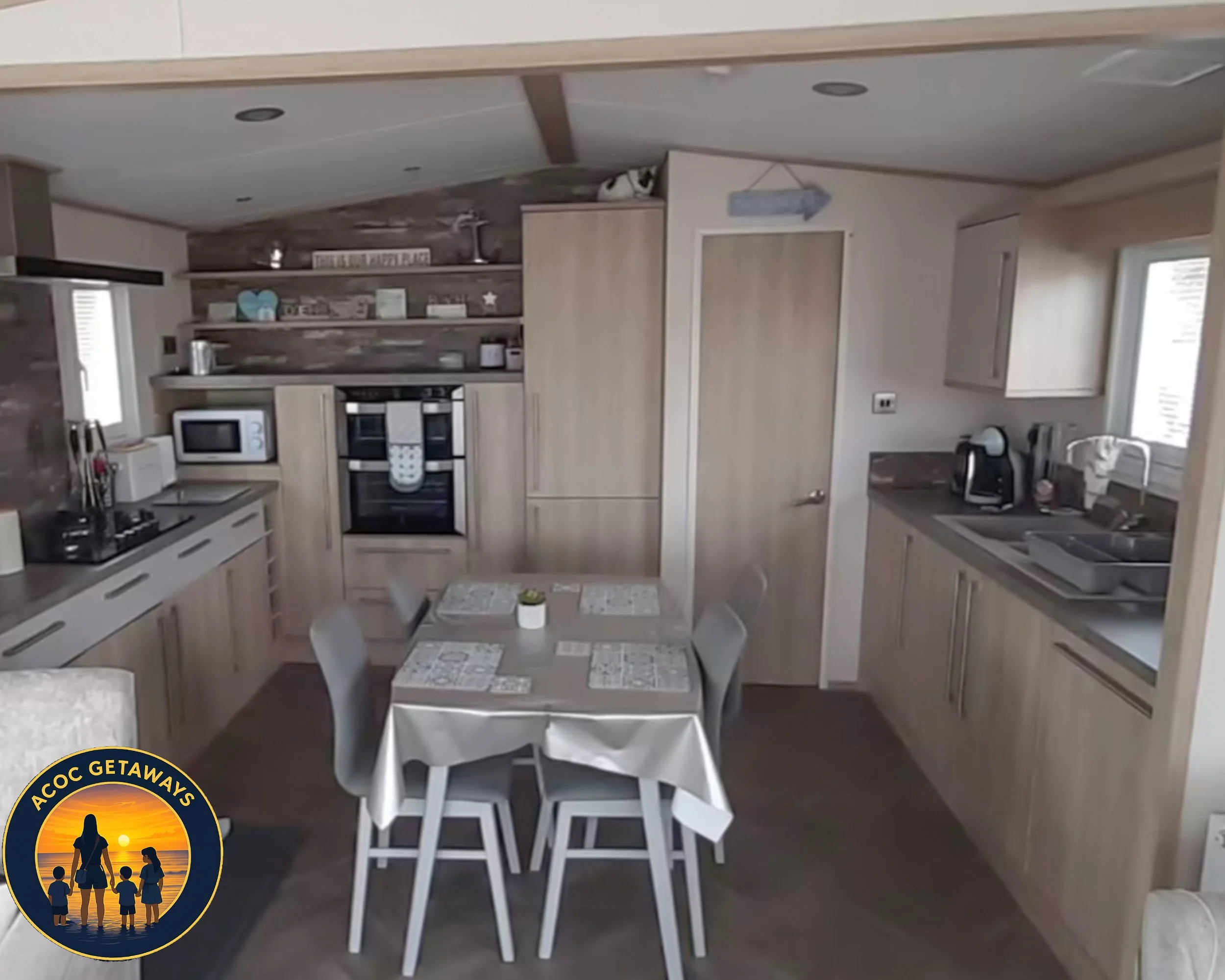 Kitchen with wooden cabinets, a dining table with four chairs, appliances like microwave, coffee maker, and oven, and decorative items on shelves.