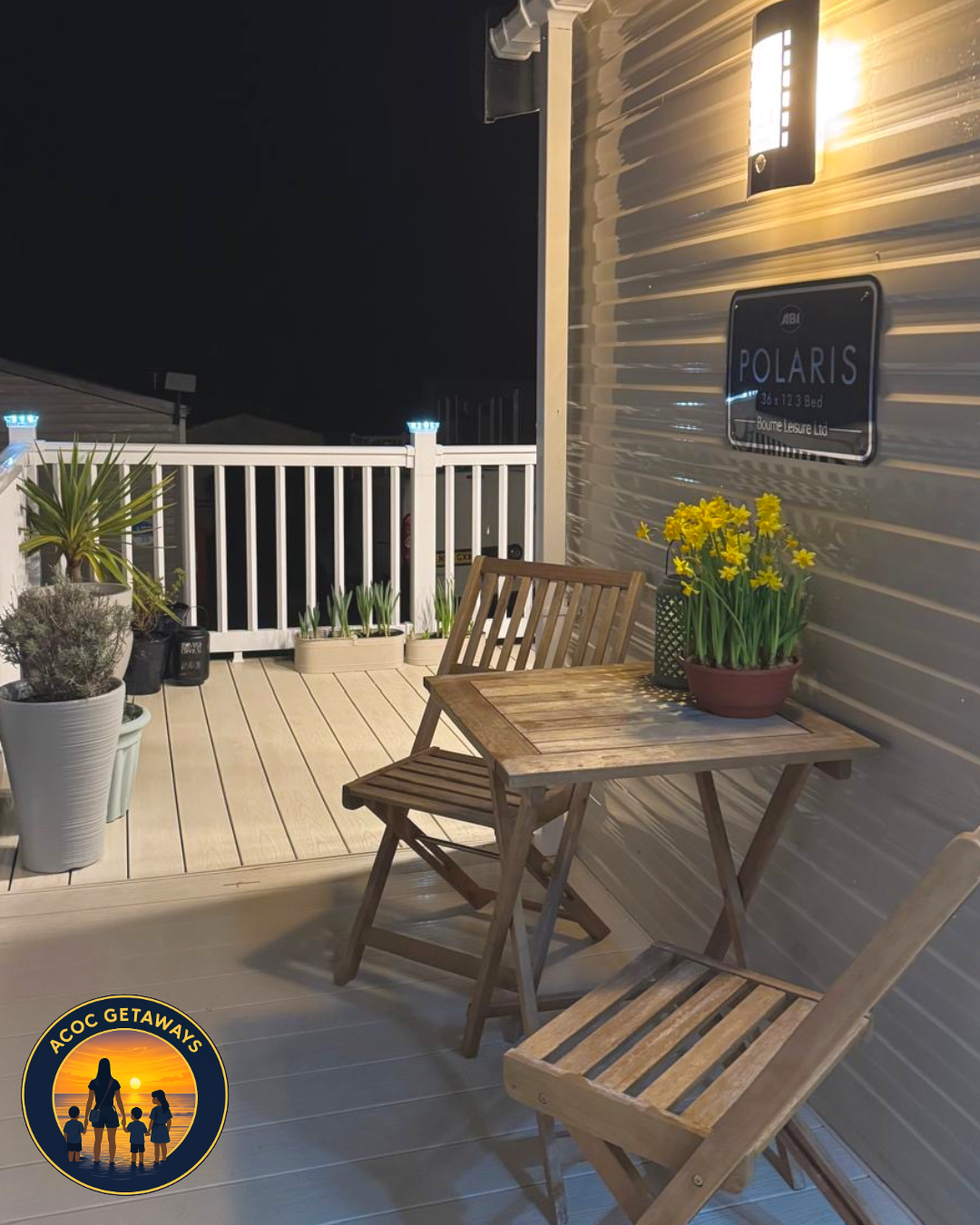 Nighttime scene of a balcony with wooden furniture, potted plants, a sign reading 'POLARIS,' and a wall-mounted light.