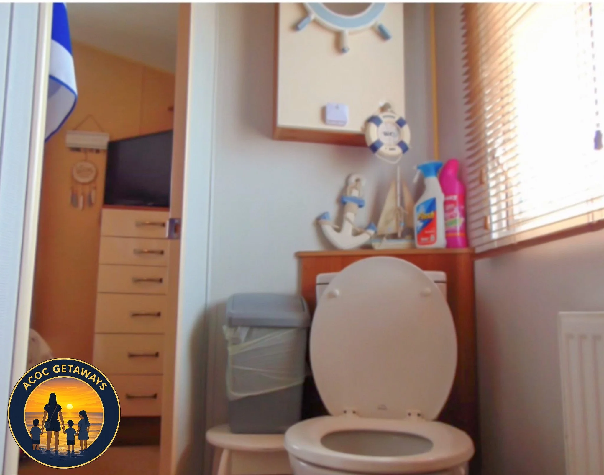 A small bathroom with a white toilet, a trash bin, a wooden shelf with nautical decorations, and a window with blinds letting in natural light.