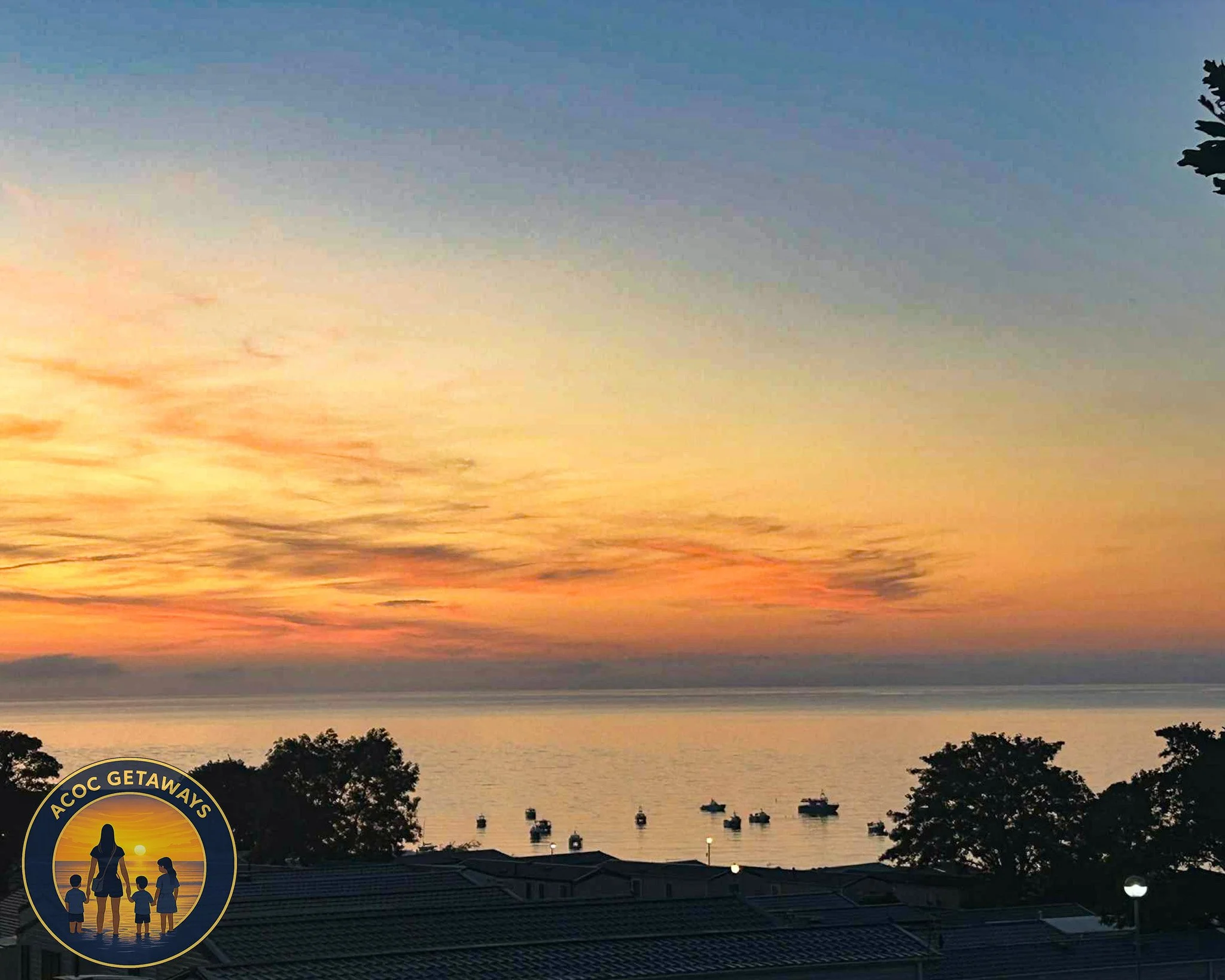 A sunset over a body of water with boats, trees, and rooftops in the foreground, and a logo with children and a sunset in the bottom left corner.