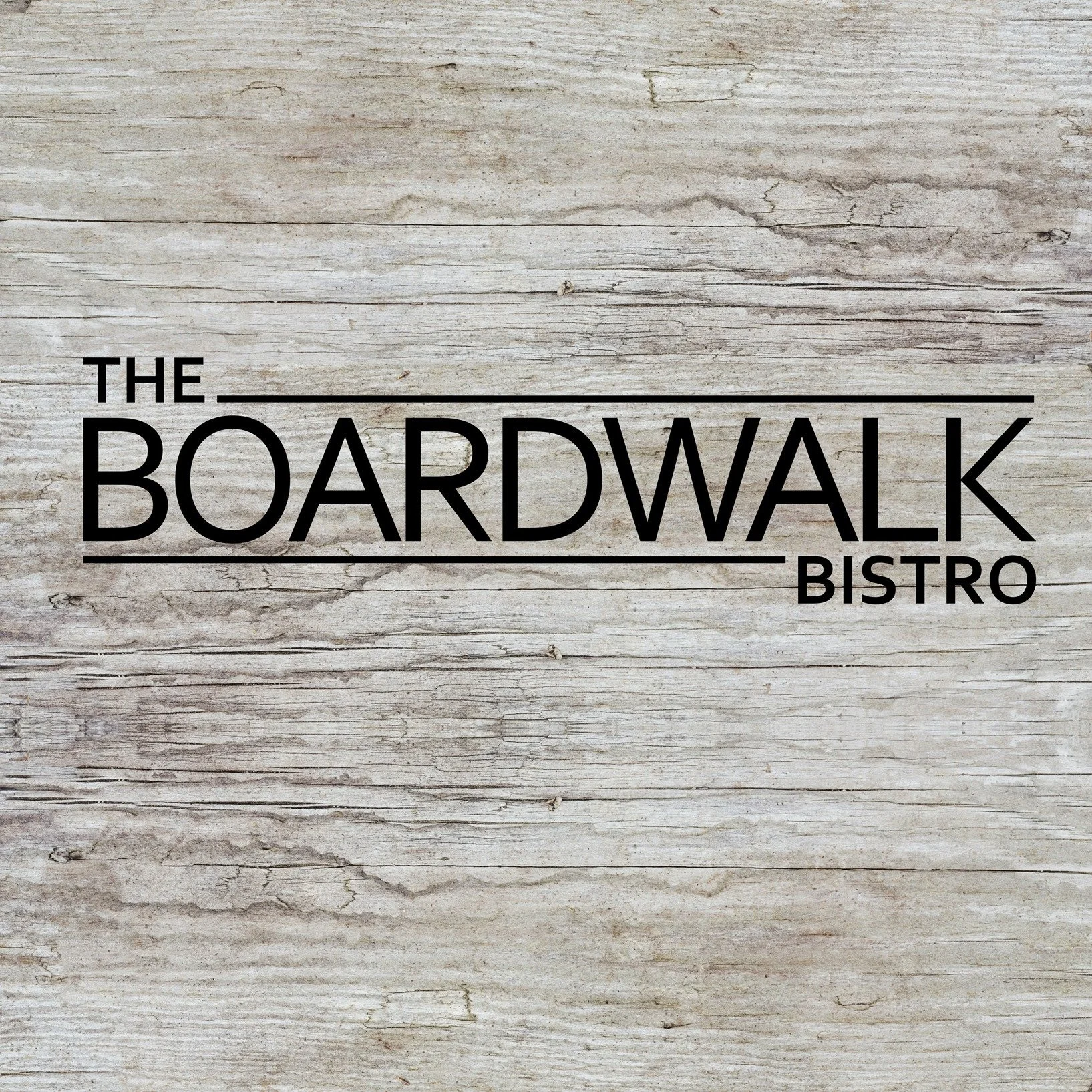 The logo for The Boardwalk Bistro on a rustic wooden background with black text and lines