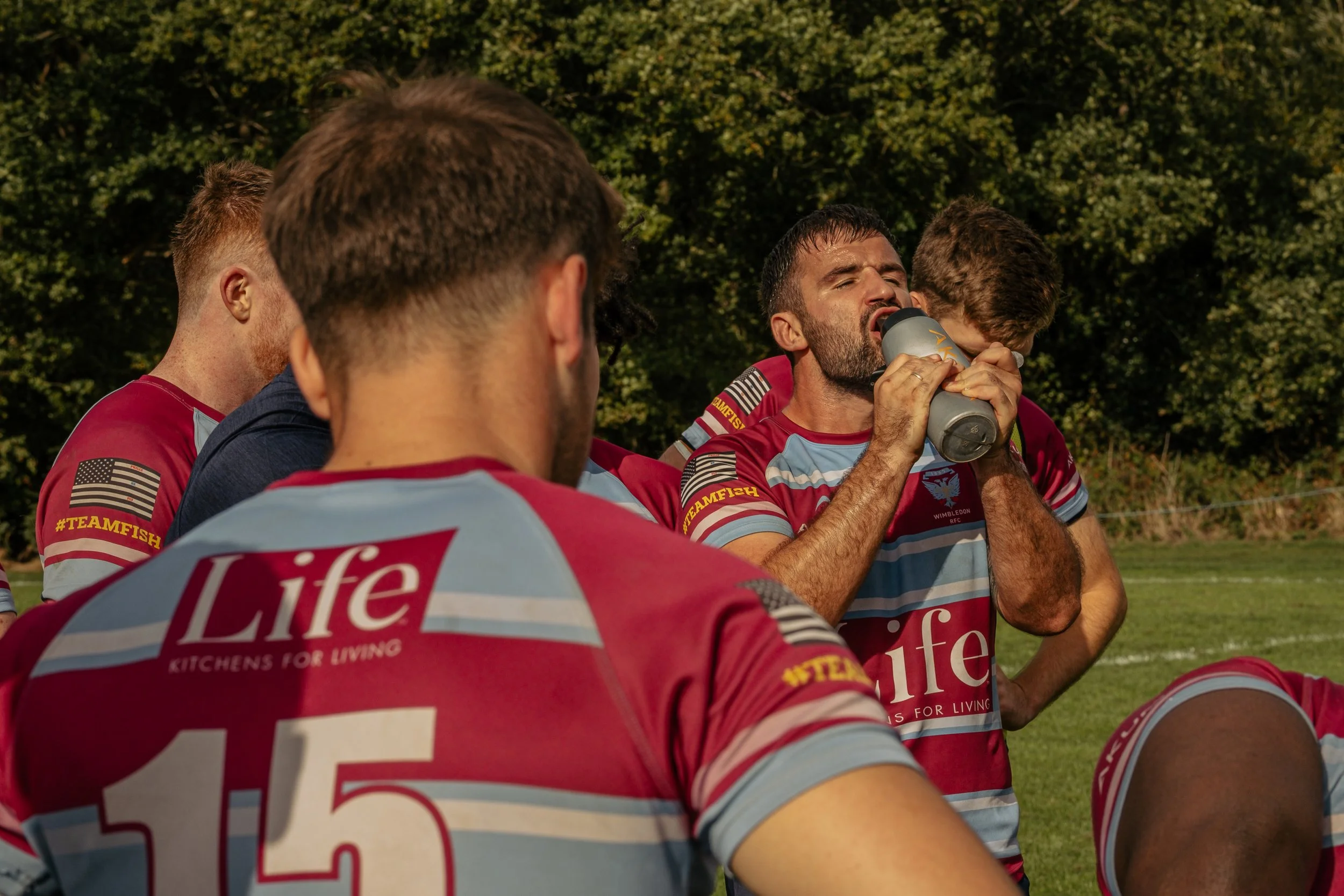 Rugby team wearing maroon and light blue jerseys, with 