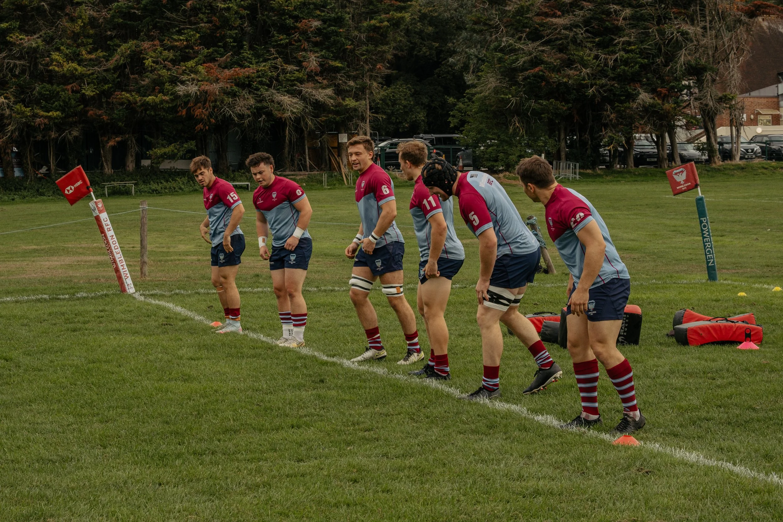 A group of rugby players in uniform walking on a grassy field, preparing for a game or practice.