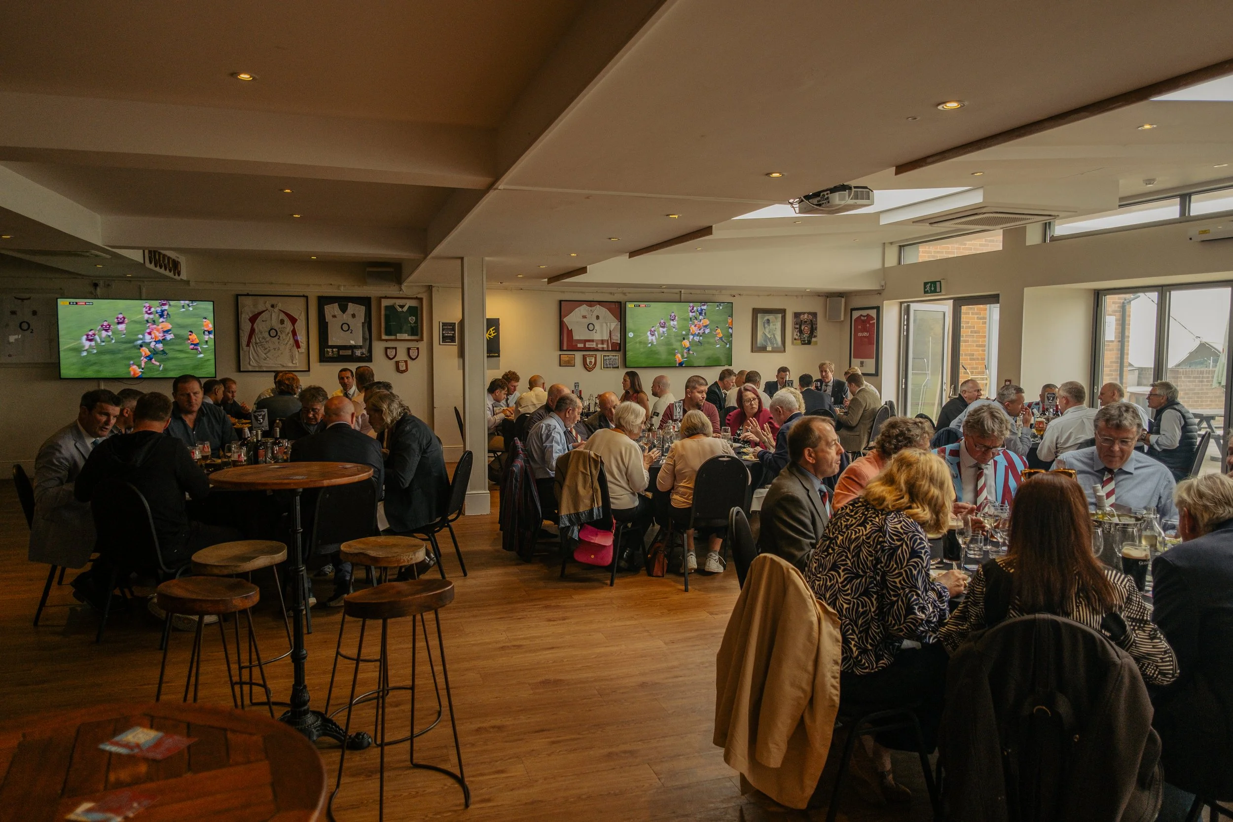 A crowded restaurant or bar filled with people watching a sports game on multiple large televisions.