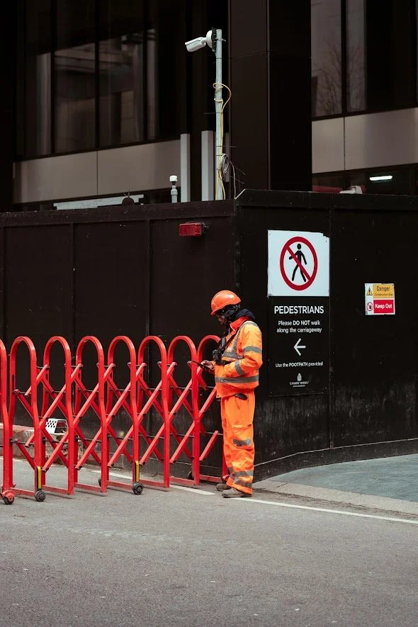 Candid portrait of a man in a hi-vis suit and hard hat in Canary Wharf, London